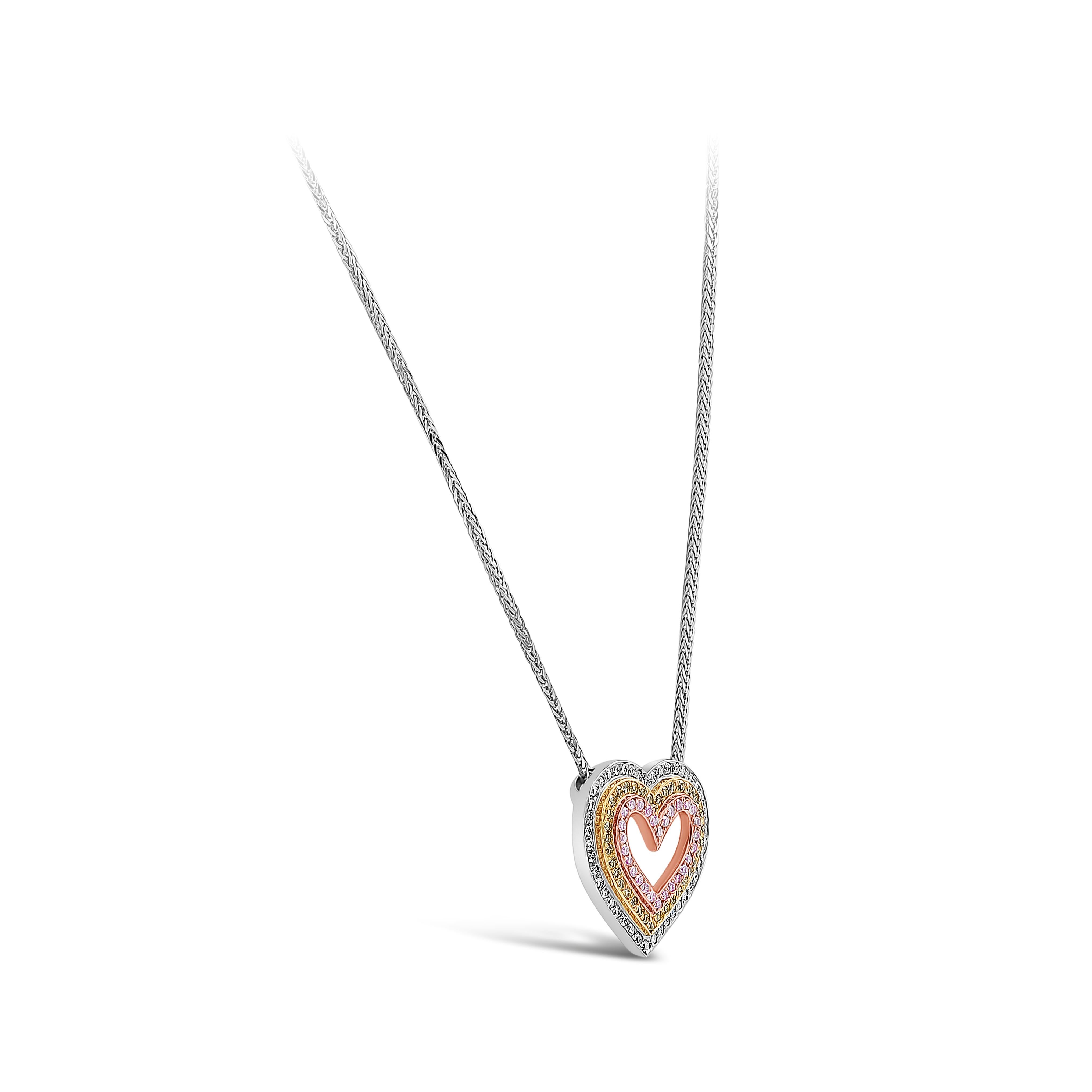 Showcasing a unique heart shape pendant necklace set with three rows of round brilliant diamonds; each row is set with a vibrant color Pink, Yellow, or white diamonds. . Suspended on an 18 inch adjustable platinum chain. Intense pink diamonds weigh