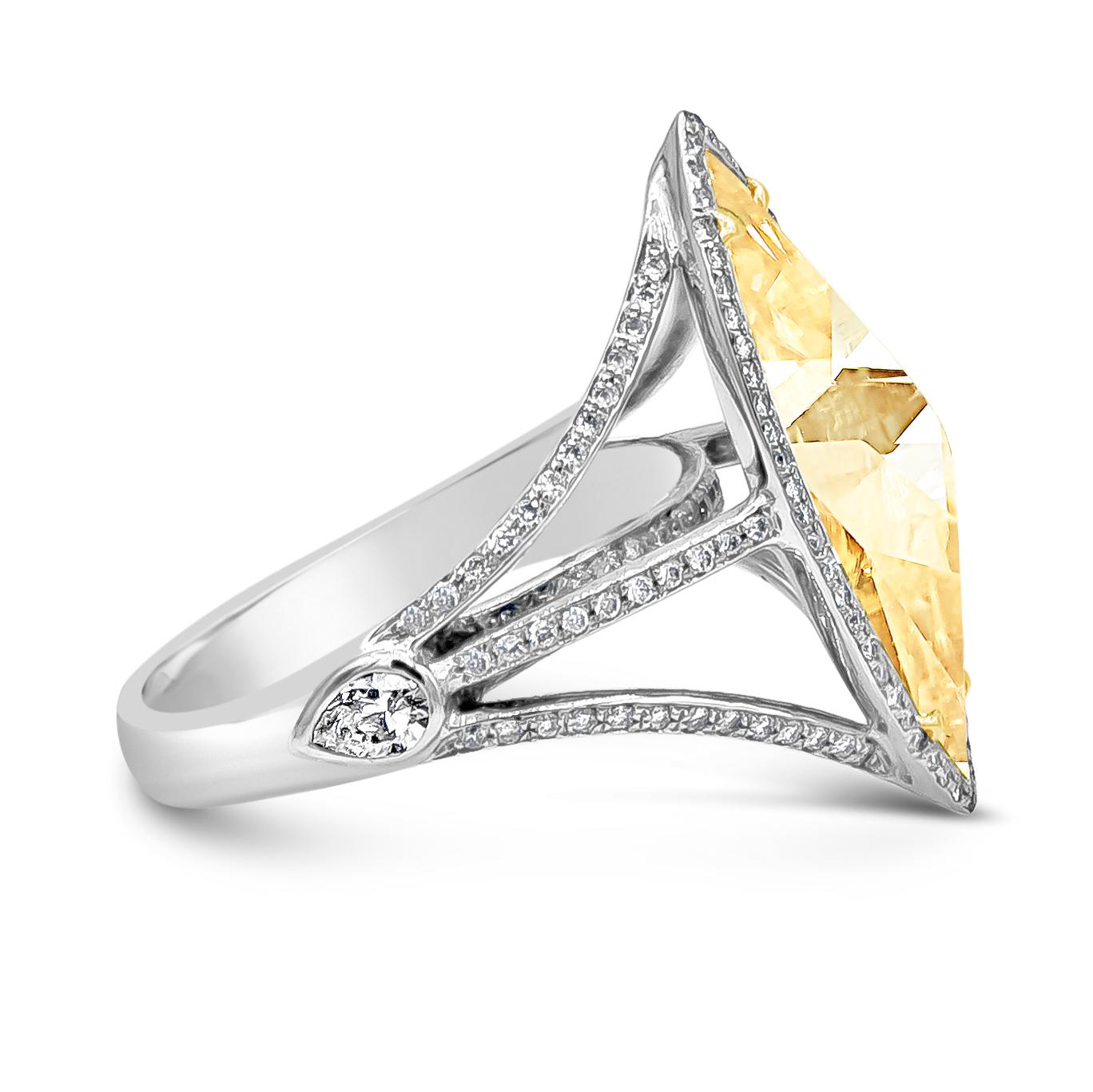 Showcasing a 3.58 carat rose cut marquise yellowish diamond, EGL certified L color and VVS2 in clarity set in a four prong 18K yellow Gold. Accented by a single row of halo round brilliant diamonds. Set in an 18 karat white gold split-shank half