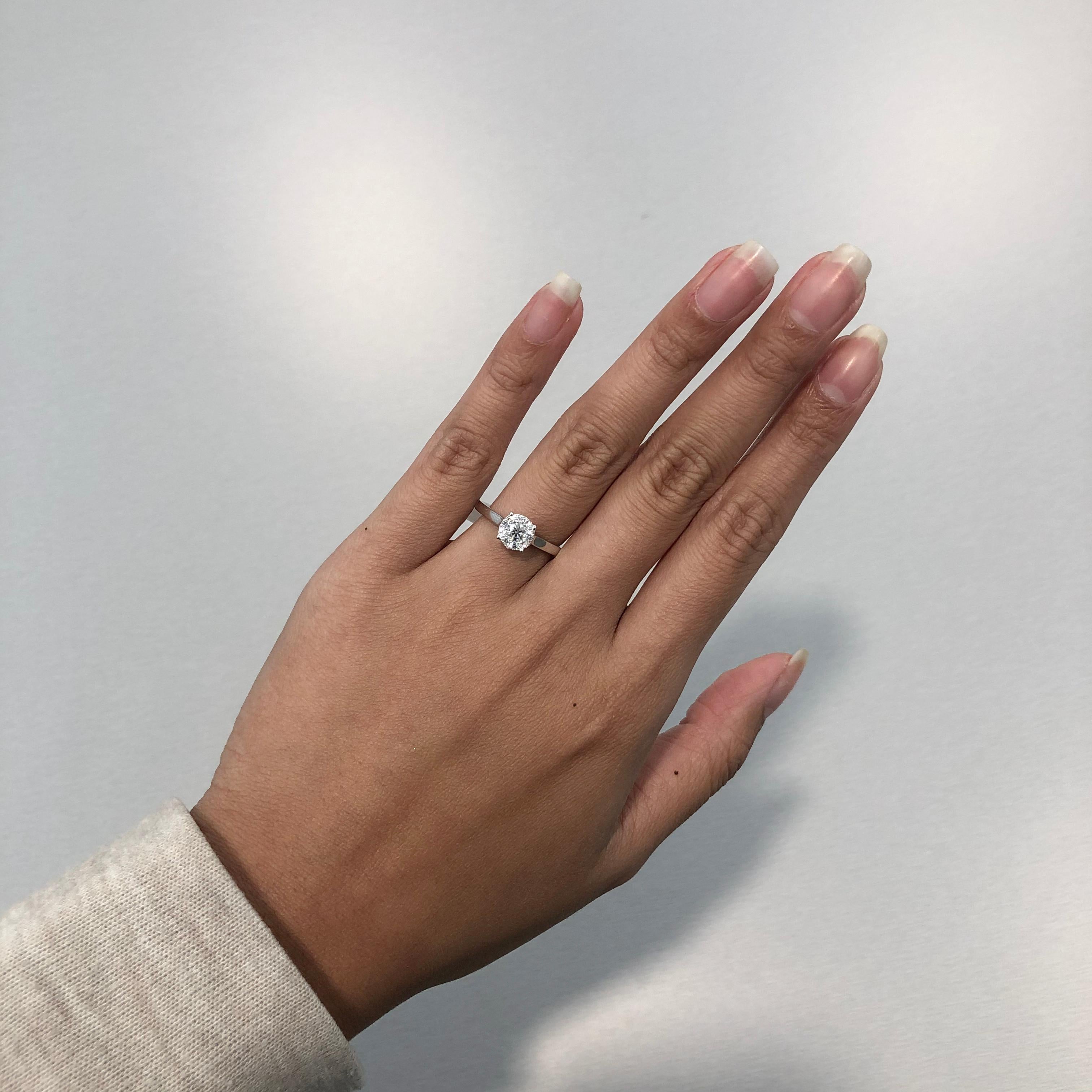 This Round Cluster Diamond Engagement Ring in 18K white gold showcases 0.39 carats of sparkling round diamonds set in a round solitaire illusion design. Finished with a handcrafted white gold composition, this ladies diamond ring makes an affordable