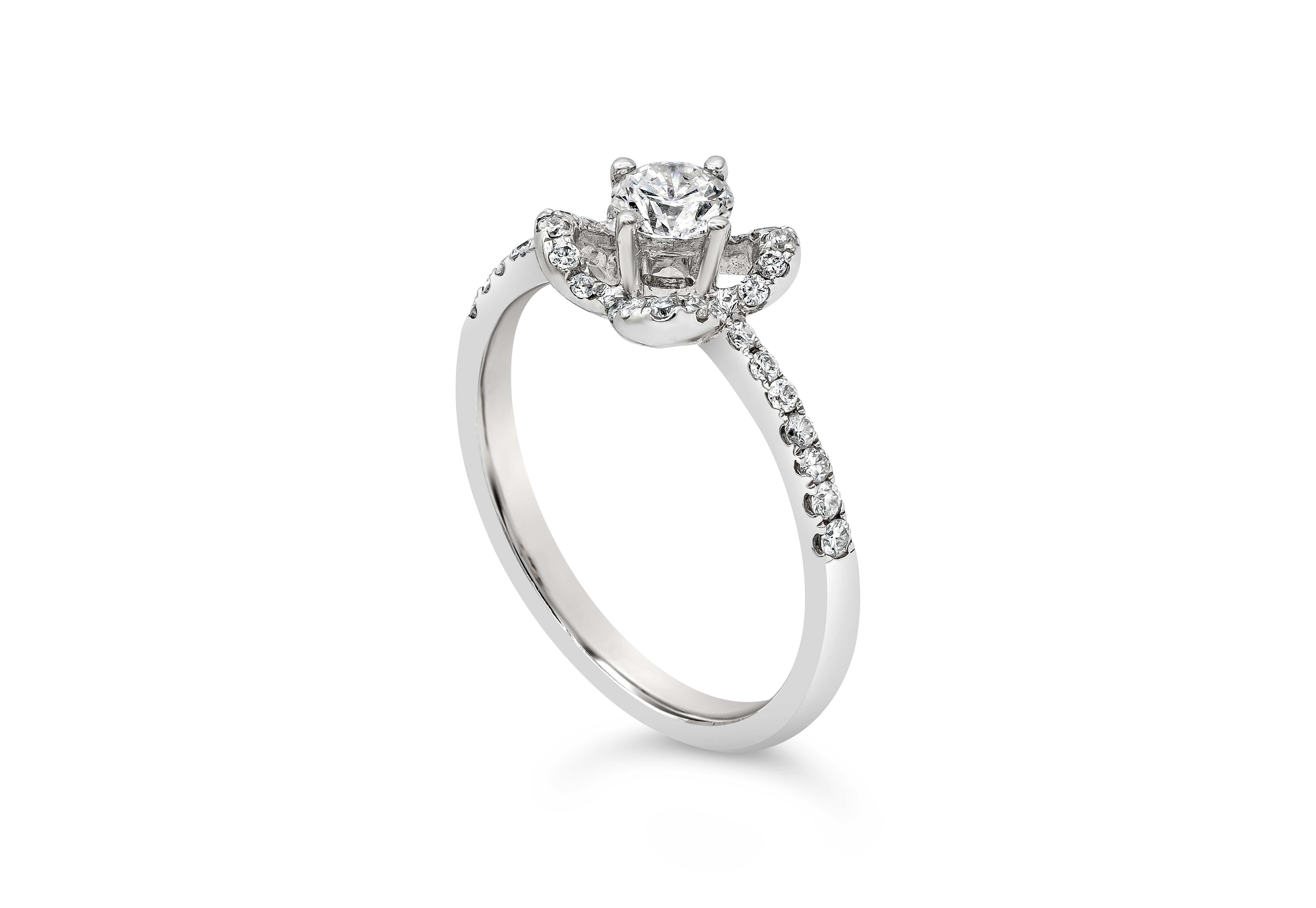 A unique and stylish engagement ring style showcasing a 0.32 carats round diamond, set in a compass setting in a diamond encrusted floral halo. Accent diamonds weigh 0.25 carats total. Made in 18K white gold. Size 6.5 US  and resizable upon