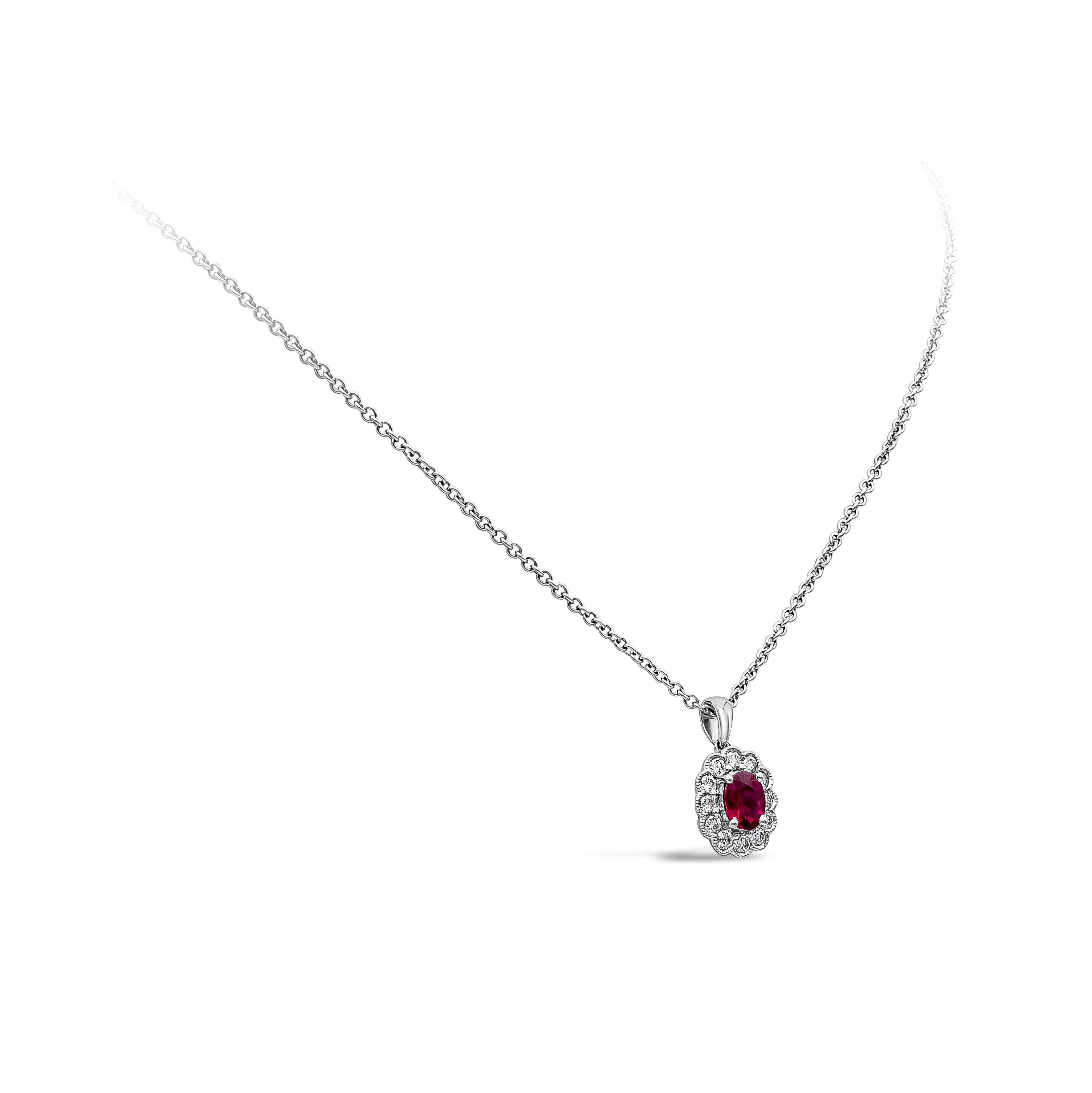 A simple classic piece of jewelry showcases an oval cut red ruby weighing 0.65 carats total, surrounded by round brilliant diamonds, set in a milgrain-edged bezel creating a floral motif mounted in 18k white gold basket. Accent diamonds weigh 0.36