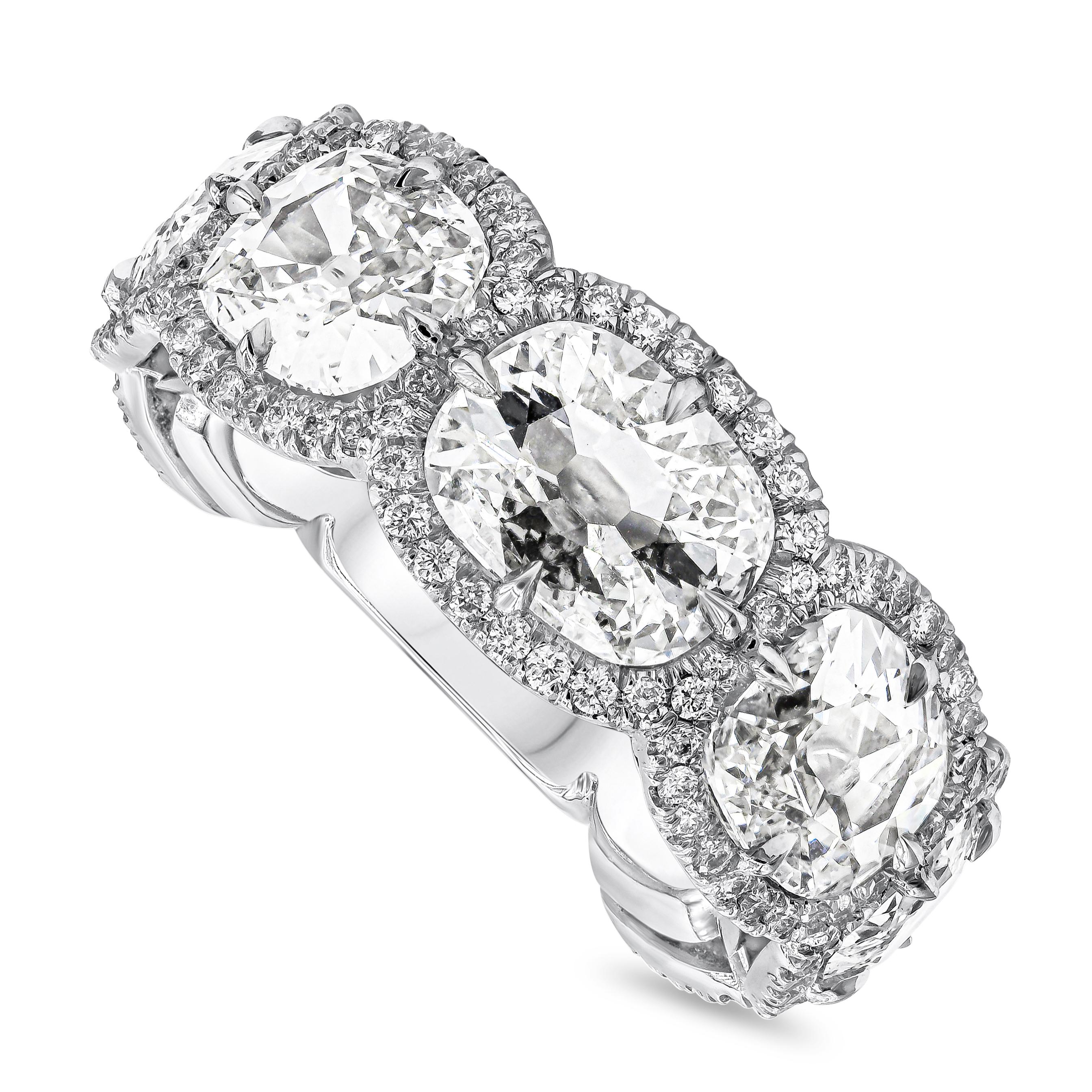 Well crafted seven stone diamond halo wedding band showcasing cushion cut diamonds weighing 5.96 carats total, each set on a four prong halo setting. Accent brilliant round diamonds weighs 0.76 carats total. Finely made in polished platinum. Size