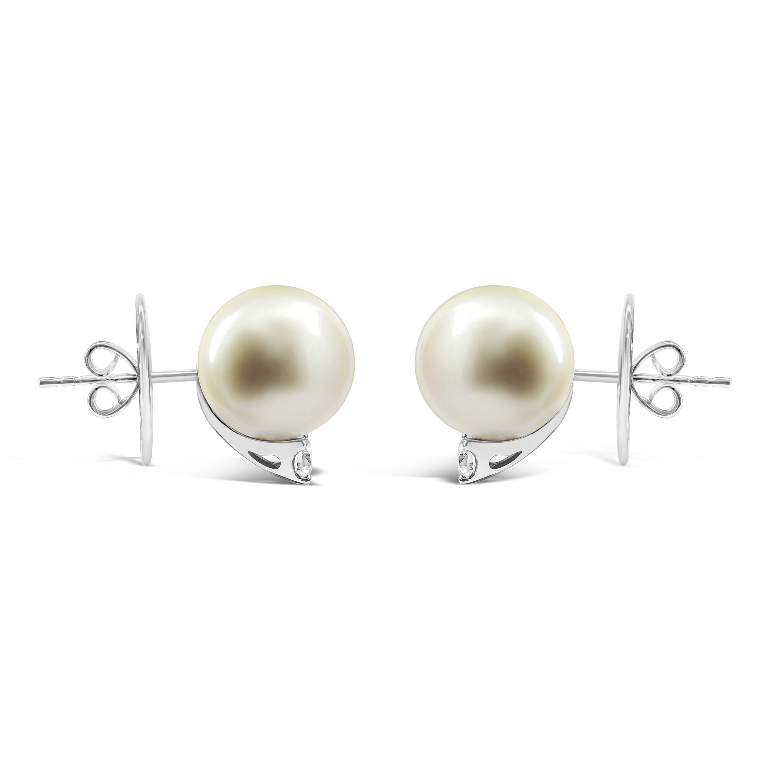 Simple stud earrings showcasing two 11.90 millimeter Tahitian pearls accented by a single round diamond. Diamonds weigh 0.31 carats total. Made in 18 karat white gold.
Style available with matching ring ,necklace and earrings. Please check our