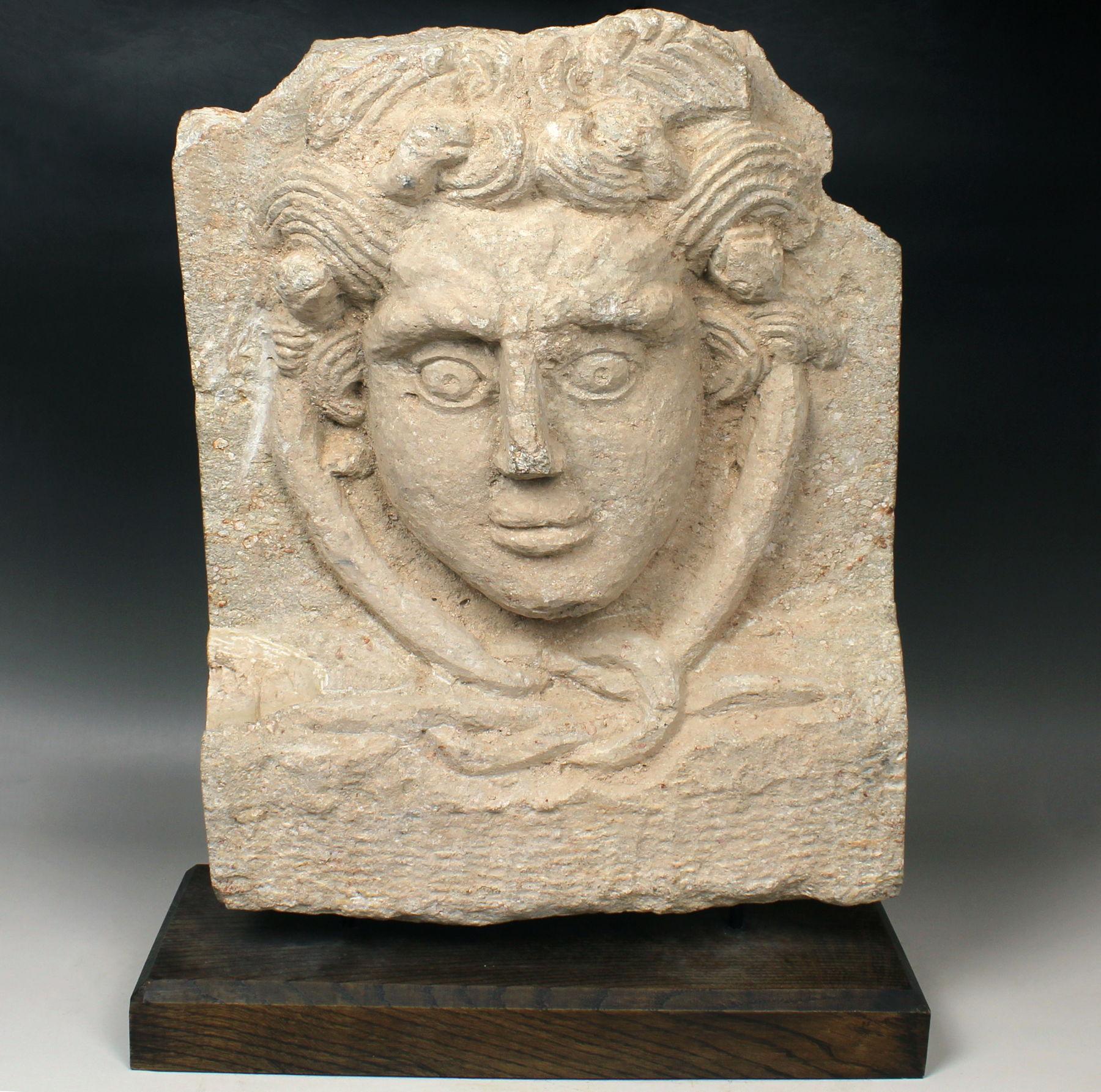 ITEM: Relief of Medusa and Hercules knot
MATERIAL: Limestone
CULTURE: Roman
PERIOD: 2nd – 3rd Century A.D
DIMENSIONS: 465 mm x 362 mm x 103 mm (without stand)
CONDITION: Good condition. Includes stand
PROVENANCE: Ex English private collection, P.A.,