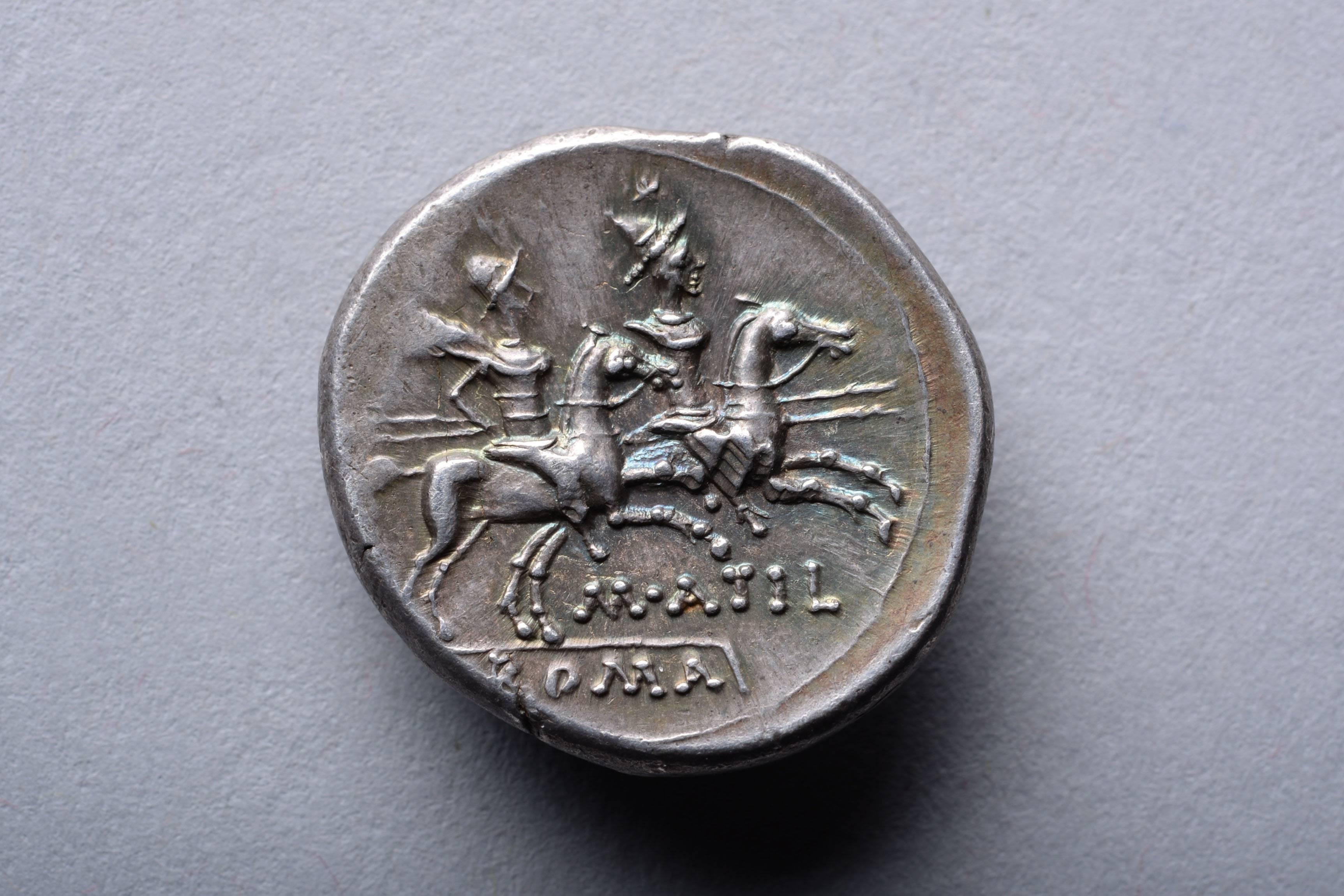 A Roman Republican denarius from the Rome mint, issued under Marcus Atilius Serranus, in 148 BC.

The obverse with Roma, wearing an elaborate crested and winged helmet and pendant earring. X in front and the inscription SARAN behind. 

The