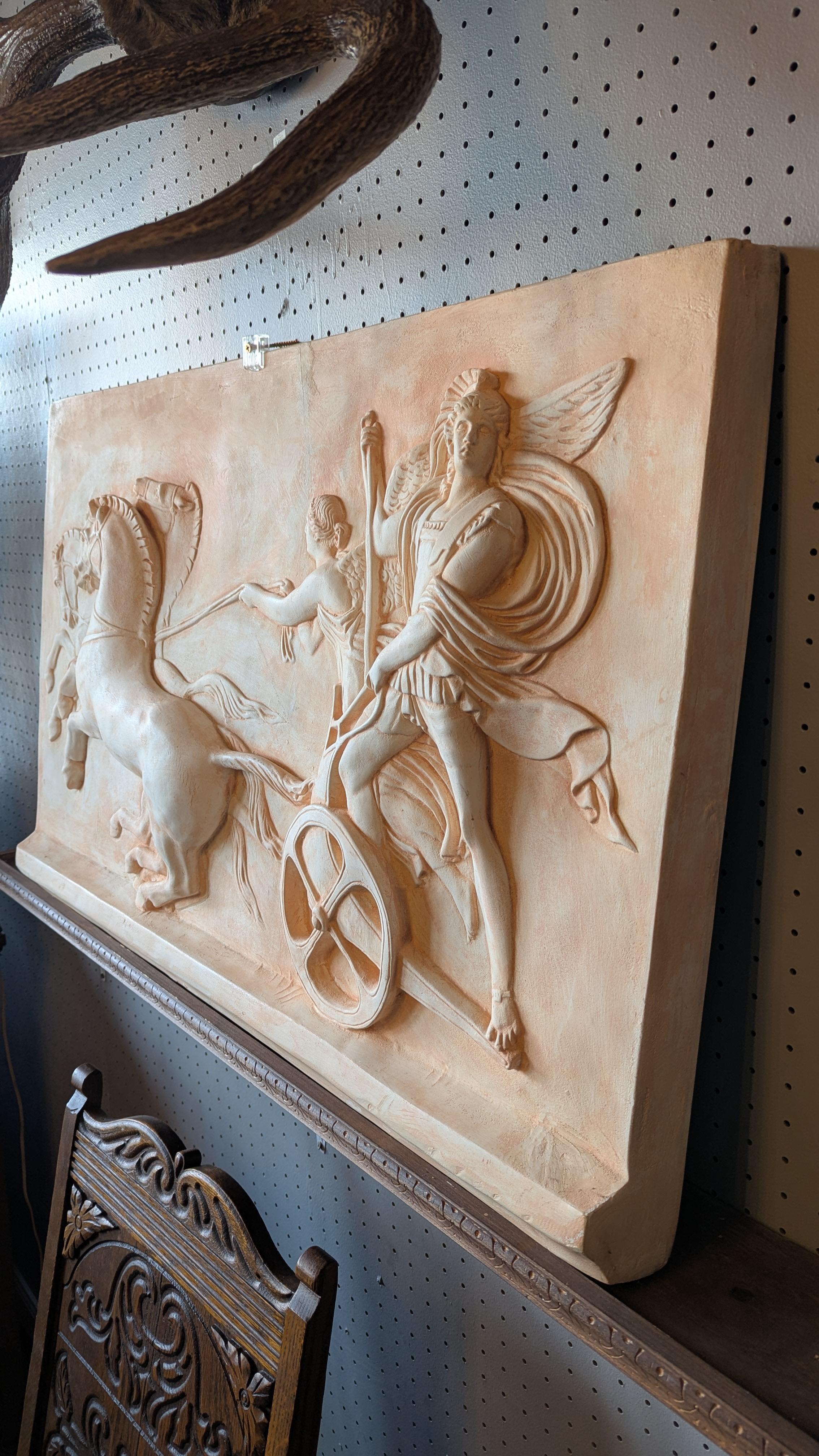 Beautiful vintage Roman chariot scene - large plaster wall hanging Frieze, with chariot, horses,  soldier, and angel relief with a peach color finish.    Display via the attached wall hanging hooks, or on an art easel, or on the wood shelf bracket