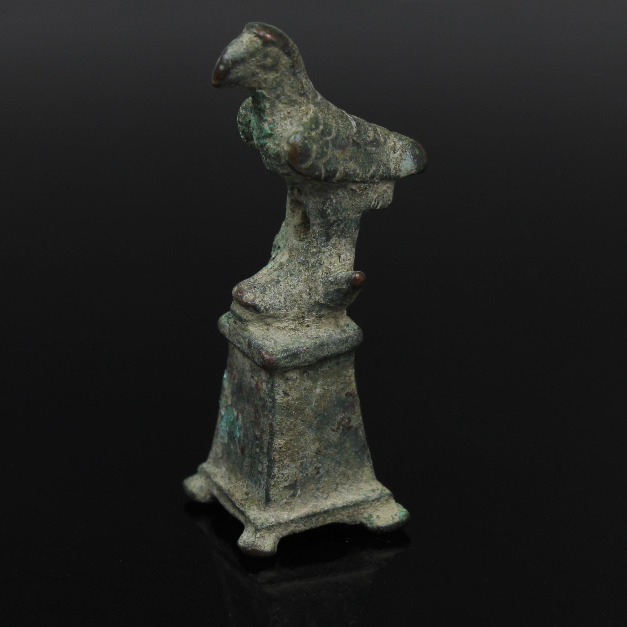 ITEM: Statuette of an eagle on pedestal
MATERIAL: Bronze
CULTURE: Roman
PERIOD: 1st – 3rd Century A.D
DIMENSIONS: 60 mm x 20 mm x 20 mm
CONDITION: Good condition
PROVENANCE: Ex German private collection, acquired before 1980s

Comes with Certificate