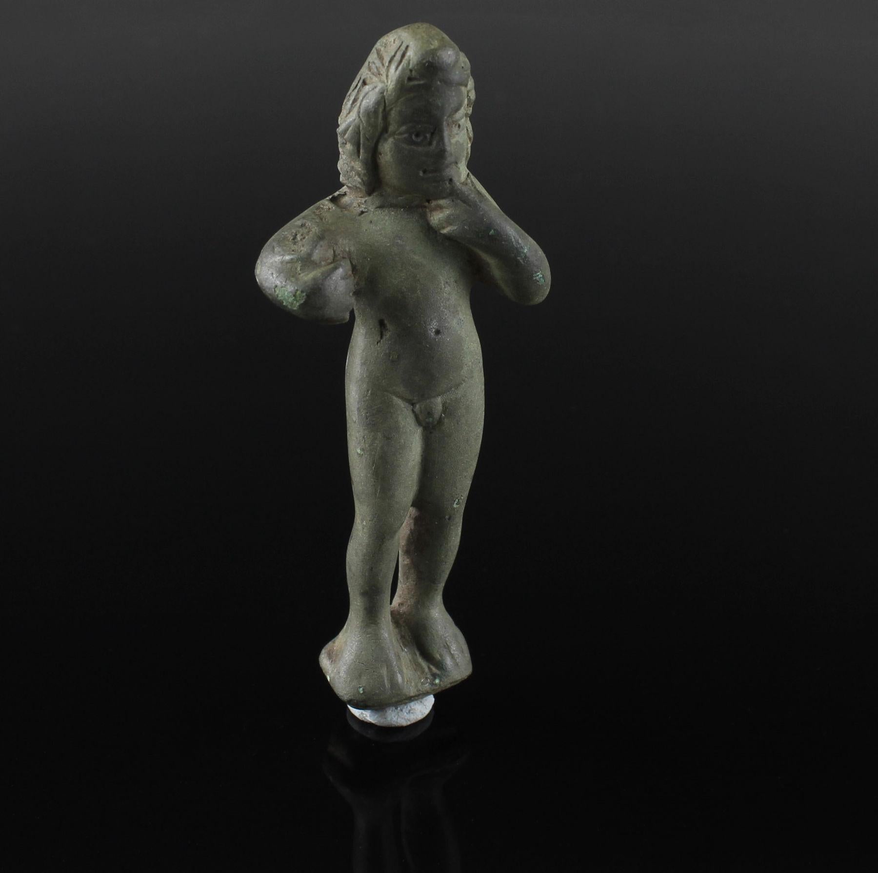 ITEM: Statuette of Eros-Harpocrates
MATERIAL: Bronze
CULTURE: Roman
PERIOD: 1st Century B.C – 1st Century A.D
DIMENSIONS: 82 mm x 31 mm
CONDITION: Good condition
PROVENANCE: Ex American private collection, collected between 1980 – 1990

Comes with