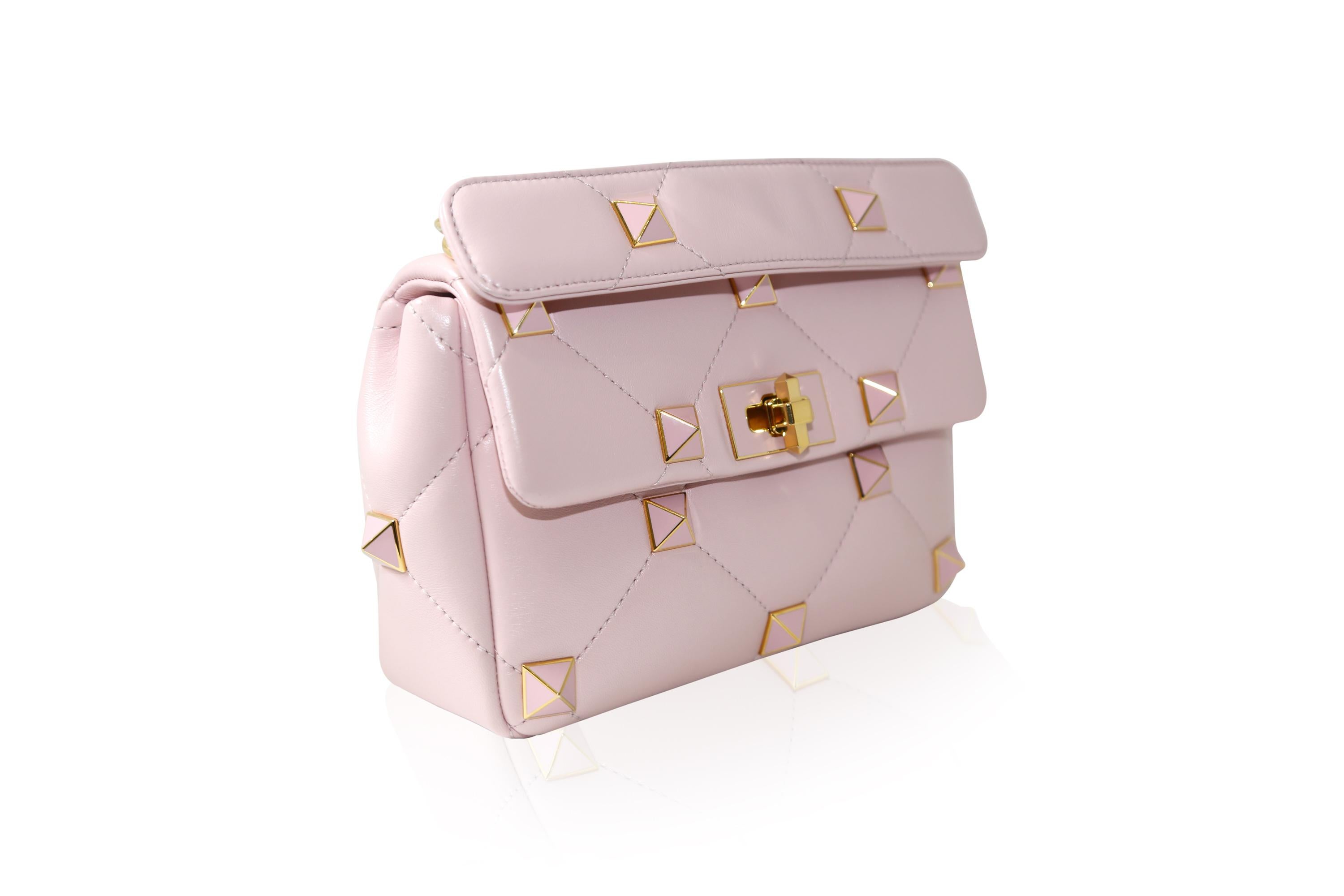 Valentino Garavani embraces a timeless colour palette with this ''Rose Quartz'' Roman Stud Medium shoulder bag. The lines of the pyramid studs are elegantly mirrored by diamond-quilted Nappa leather. Make yours a glamorous plus-one for evenings