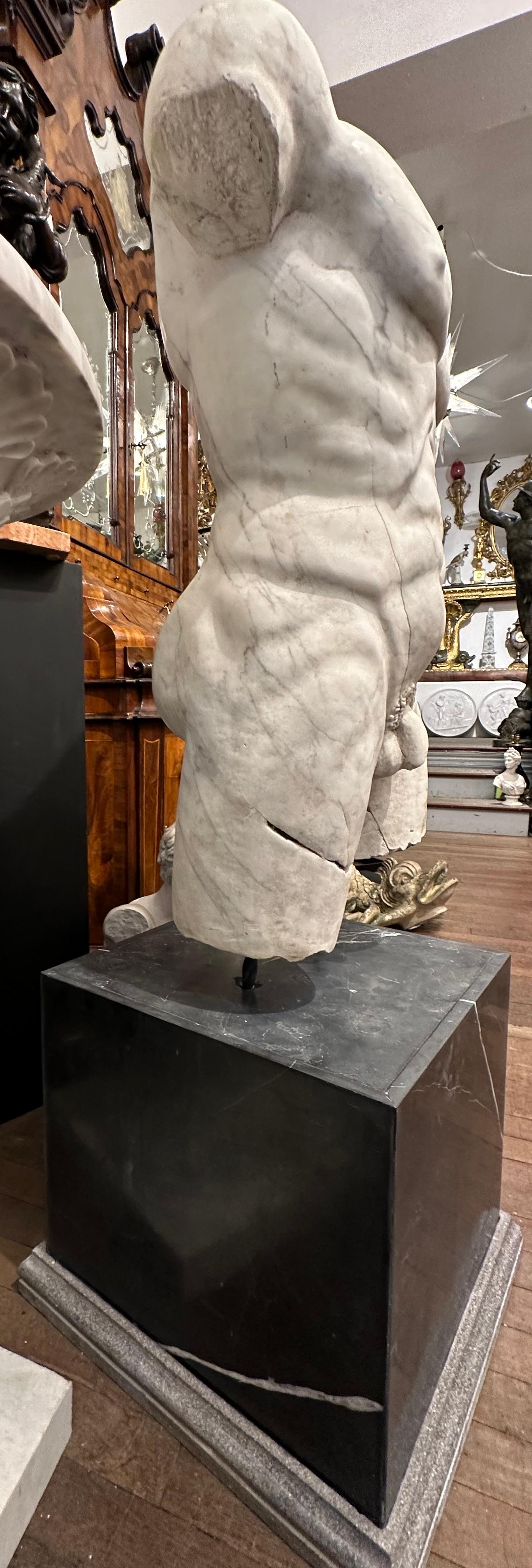 Hand-Carved Roman Style Marble Torso On A Black Marble Base For Sale