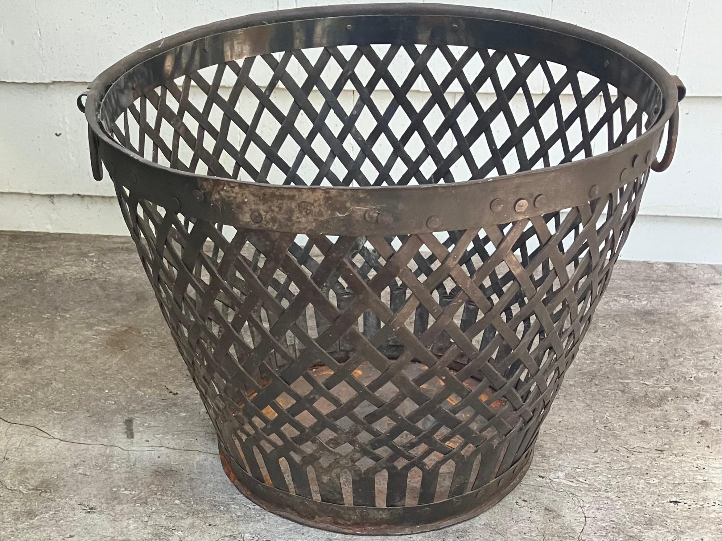 Antique Roman Style one of a kind metal work litter or trash can of interwoven metal in a basketweave design with nailheads and ring handles. United States, 19th century
Dimensions:  13 1/2” handle to handle x 9 7/8” H; 8 3/4” dia base 