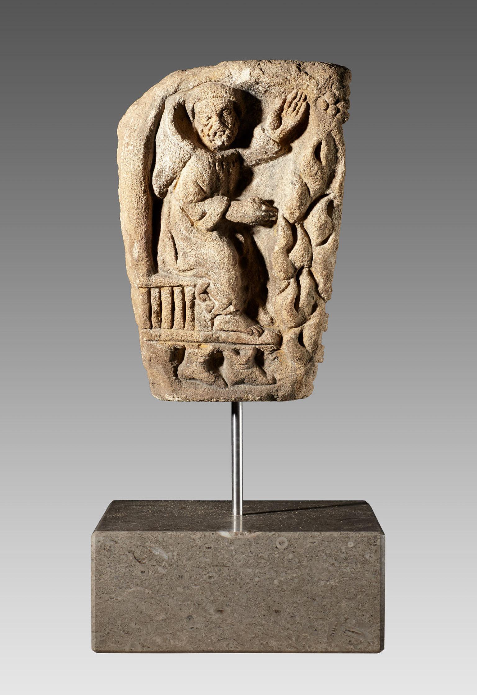 Late Romanesque Limestone capital, French, circa 1150-1250.

The tapered Capital carved in high relief to three sides with scenes from the ‘Labours Of The Months’. A seated monk warming feet and hands depicting February, the treading of grapes for