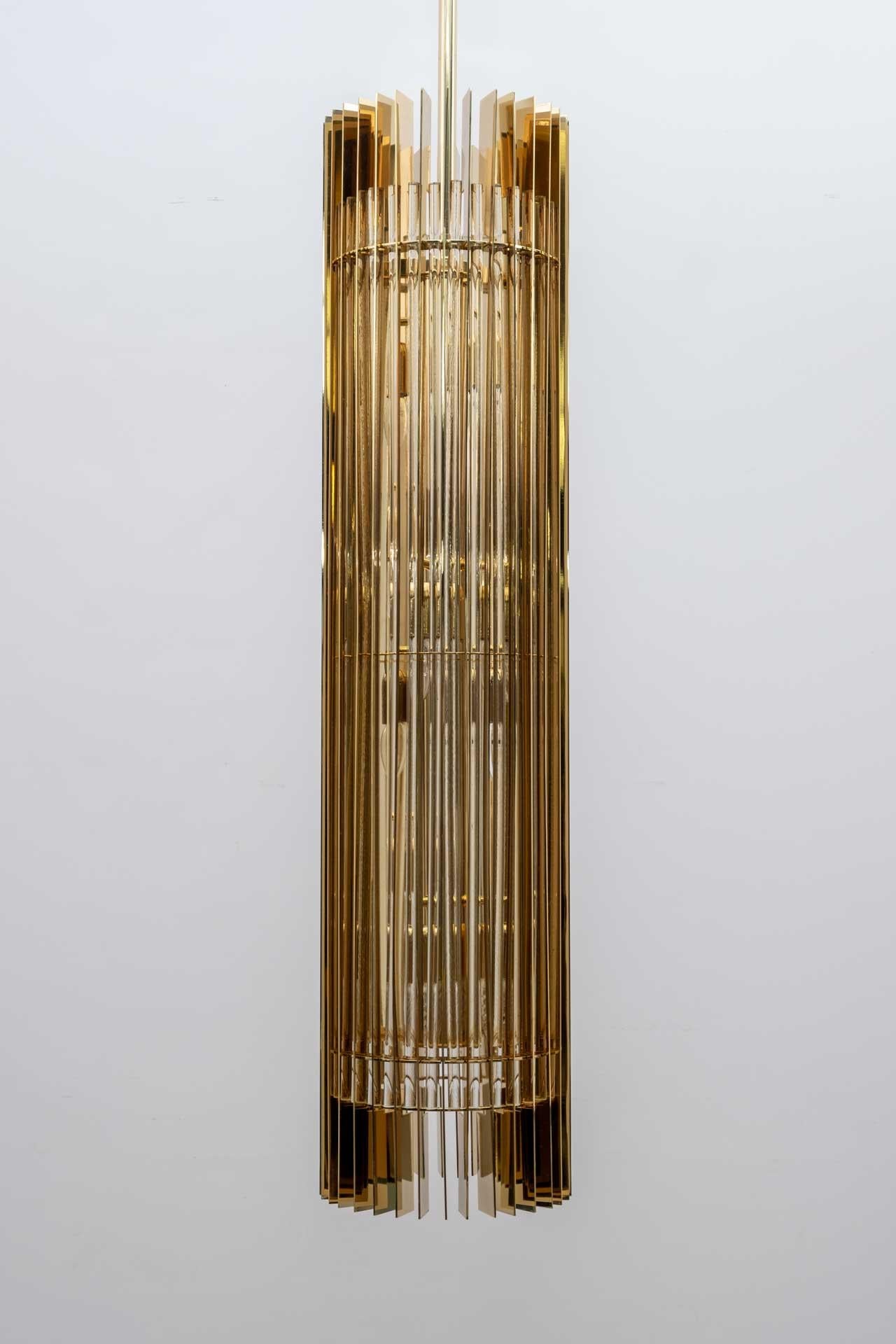 Lampe à suspension conçue exclusivement pour les intérieurs des magasins Gucci. Conçu par Romani Saccati Architetti et produit en 2005 par Studio Design Italia. La base métallique est en laiton laqué, les tiges sont en cristal poli miroir, huit