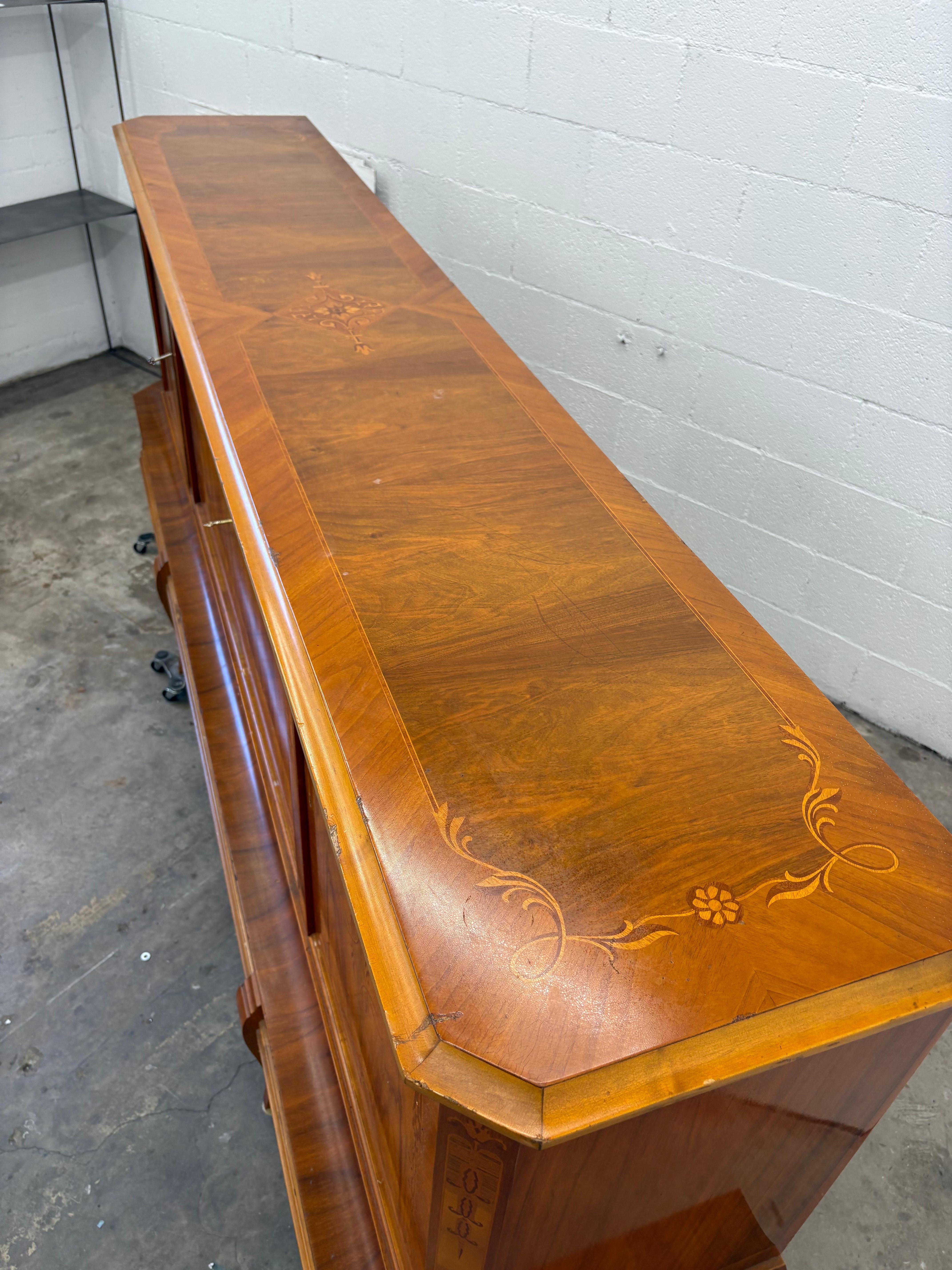 Crafted with exotic wood inlays, this Romanian Art Deco sideboard showcases exceptional European craftsmanship and large-scale design. Measuring 100 inches long, it features three upper compartments with removable shelves and four lower pull-out