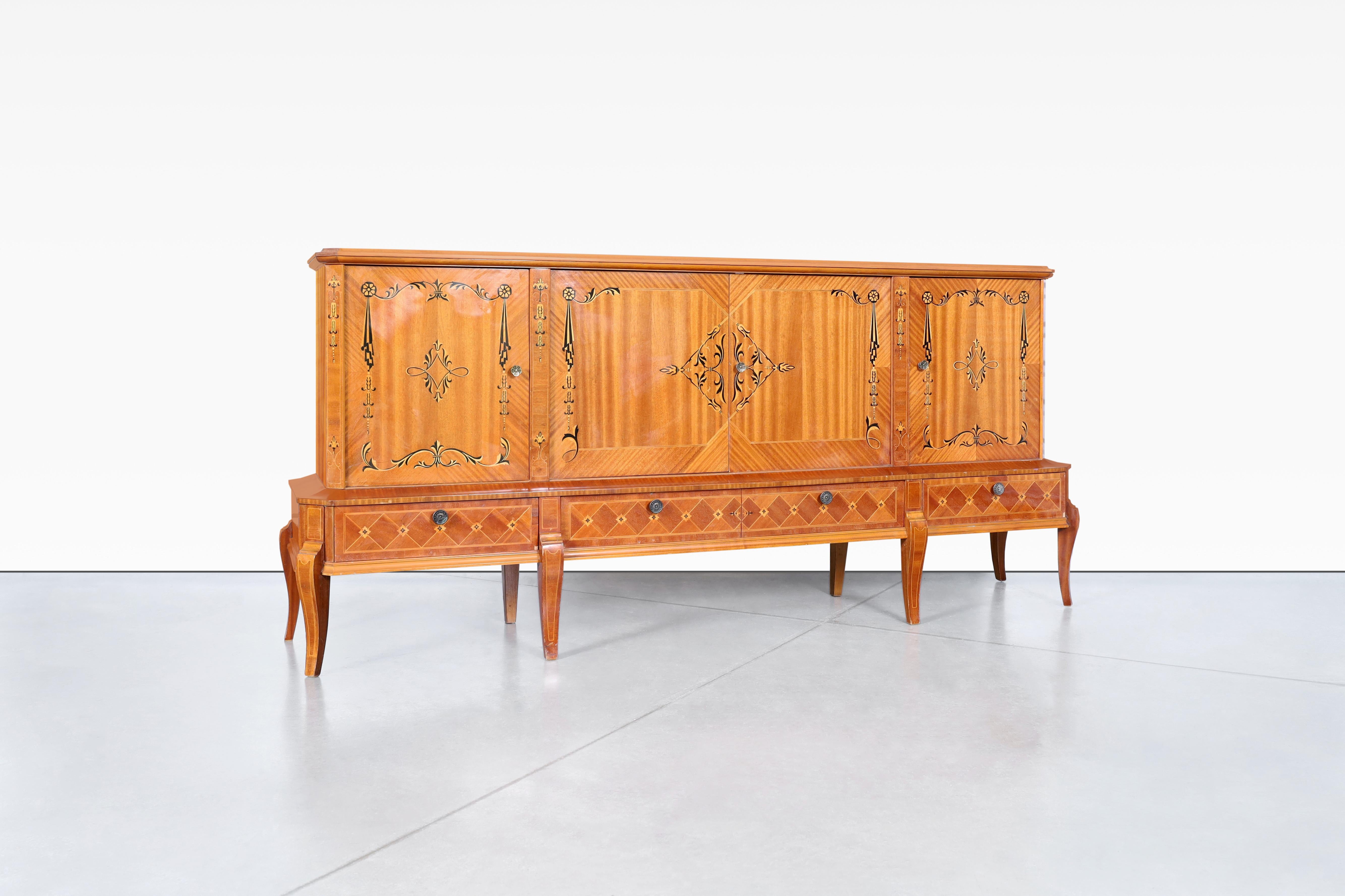 Questa splendida credenza Art Deco rumena, risalente agli anni '40, emana un'eleganza senza tempo e un'eccezionale maestria. La parte superiore è decorata con tre spaziosi scomparti, completi di ripiani rimovibili, mentre la parte inferiore presenta