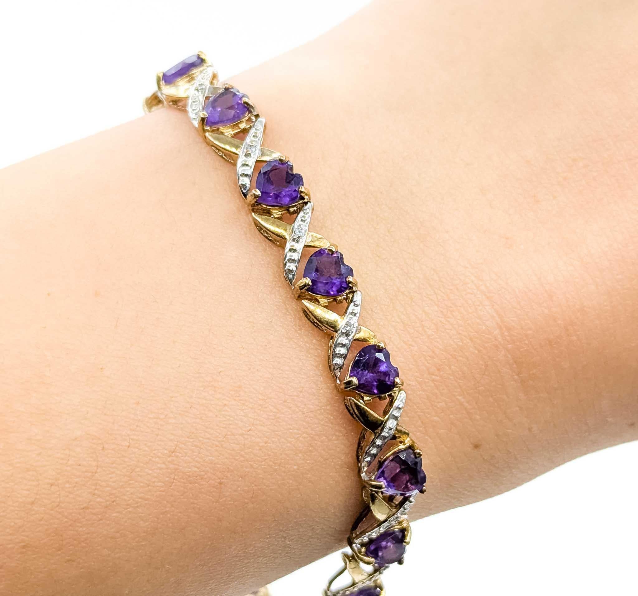 Ce charmant bracelet en or jaune 10k est orné d'un motif romantique en forme de cœur. Sertie de 4,00 carats d'améthystes taillées en cœur, chaque pierre précieuse est rehaussée de délicates touches de diamant totalisant 0,04 carat, ajoutant ainsi la
