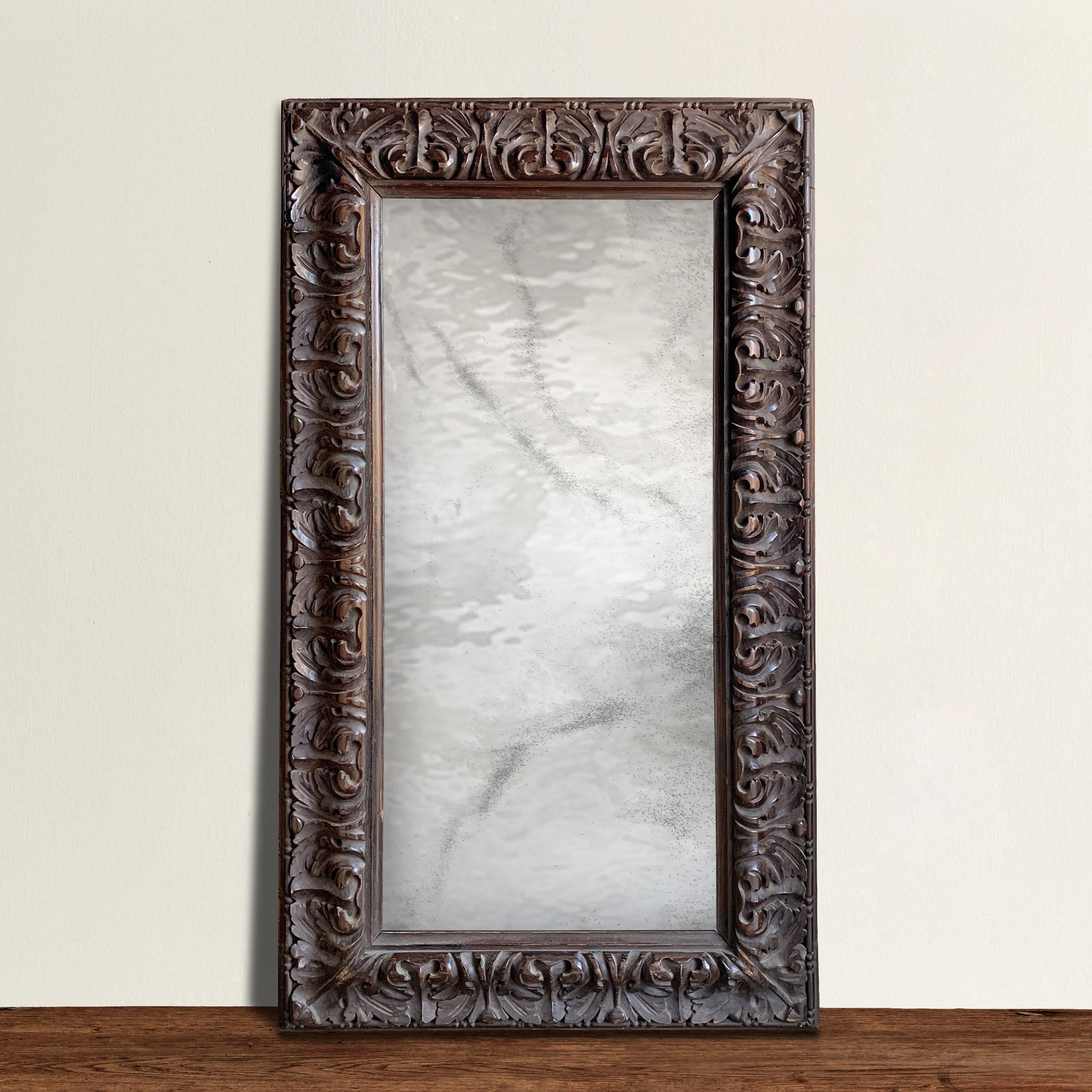 An outstanding and romantic 19th century Italian hand carved wood frame with a classical acanthus leaf motif and with a custom antiqued wavy glass mirror. From a distance, anything in the mirror is wonderfully distorted, but things come into view as
