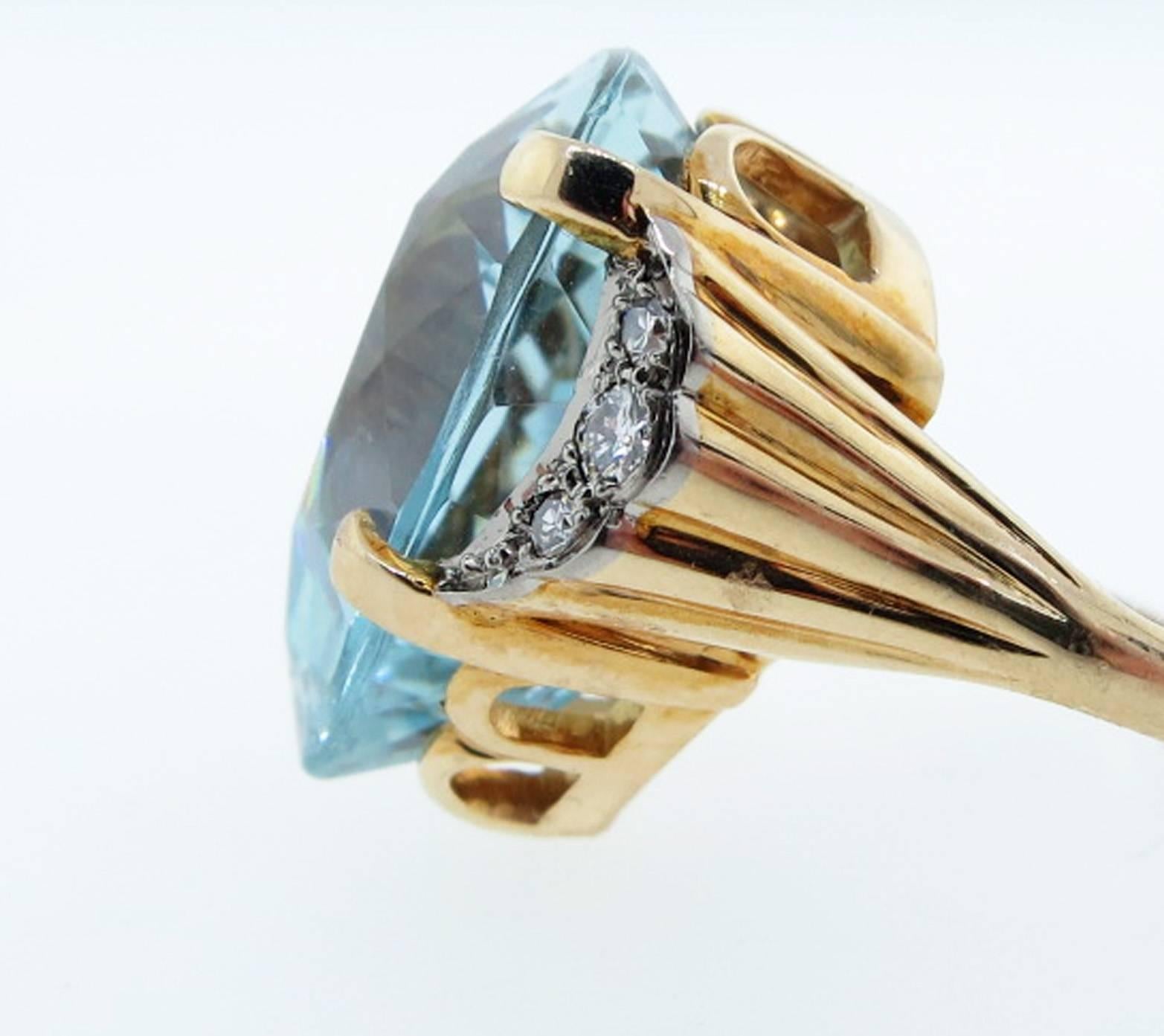 Gleaming 14kt. yellow gold handmade aquamarine and diamond ring. The center is set with a fine color faceted natural aquamarine weighing approx 20.0cts. Each shoulder is bead set in white gold with 3 round brilliant cut diamonds totaling approx .20