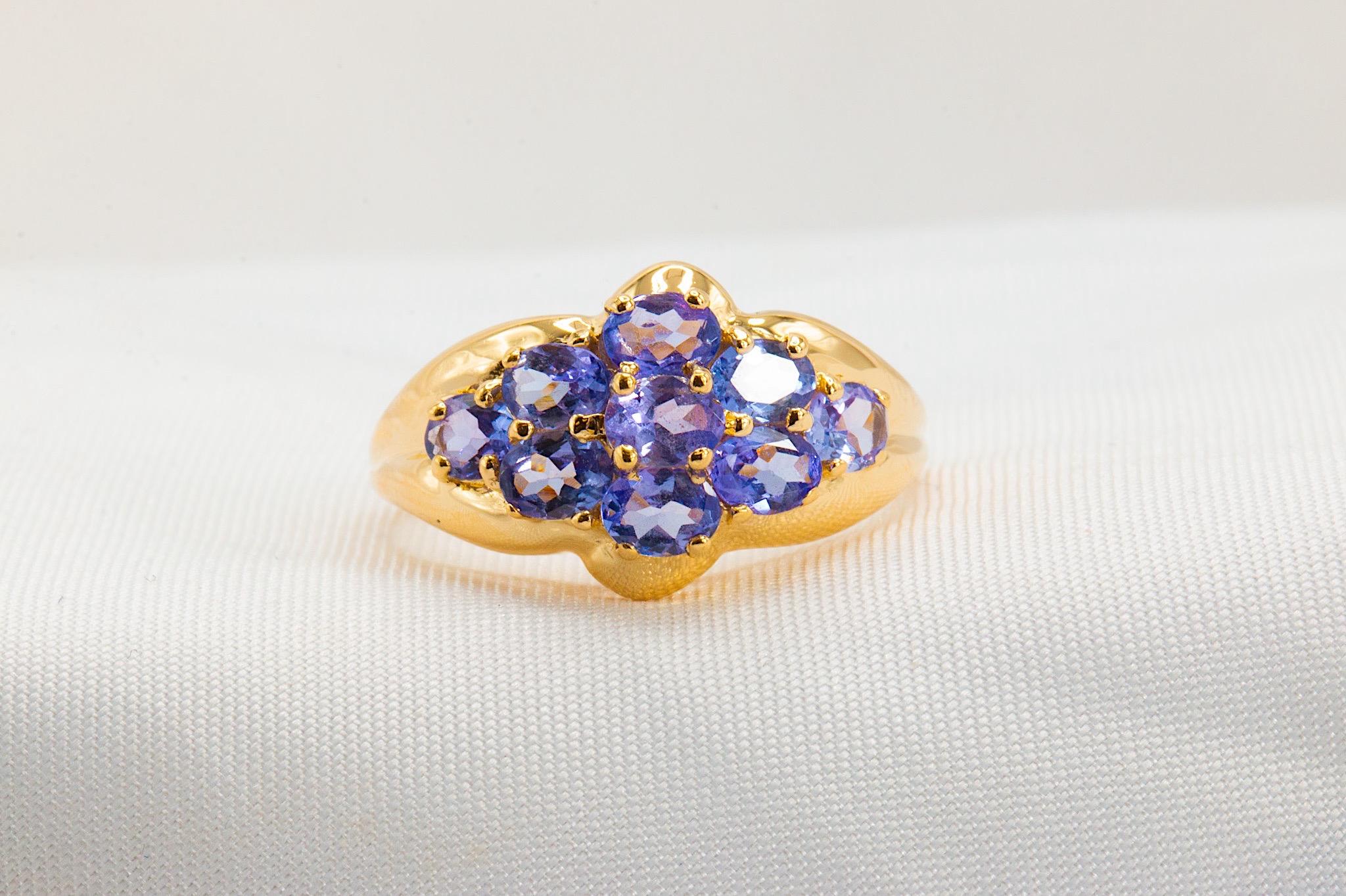 Romance your loved one with this beautiful clustered vintage band. The ring is outfitted with a bouquet of nine oval-cut tanzanite stones in a pale forget-me-not blue, weighing approximately 2ct. altogether. 

The band is 11mm at its widest and