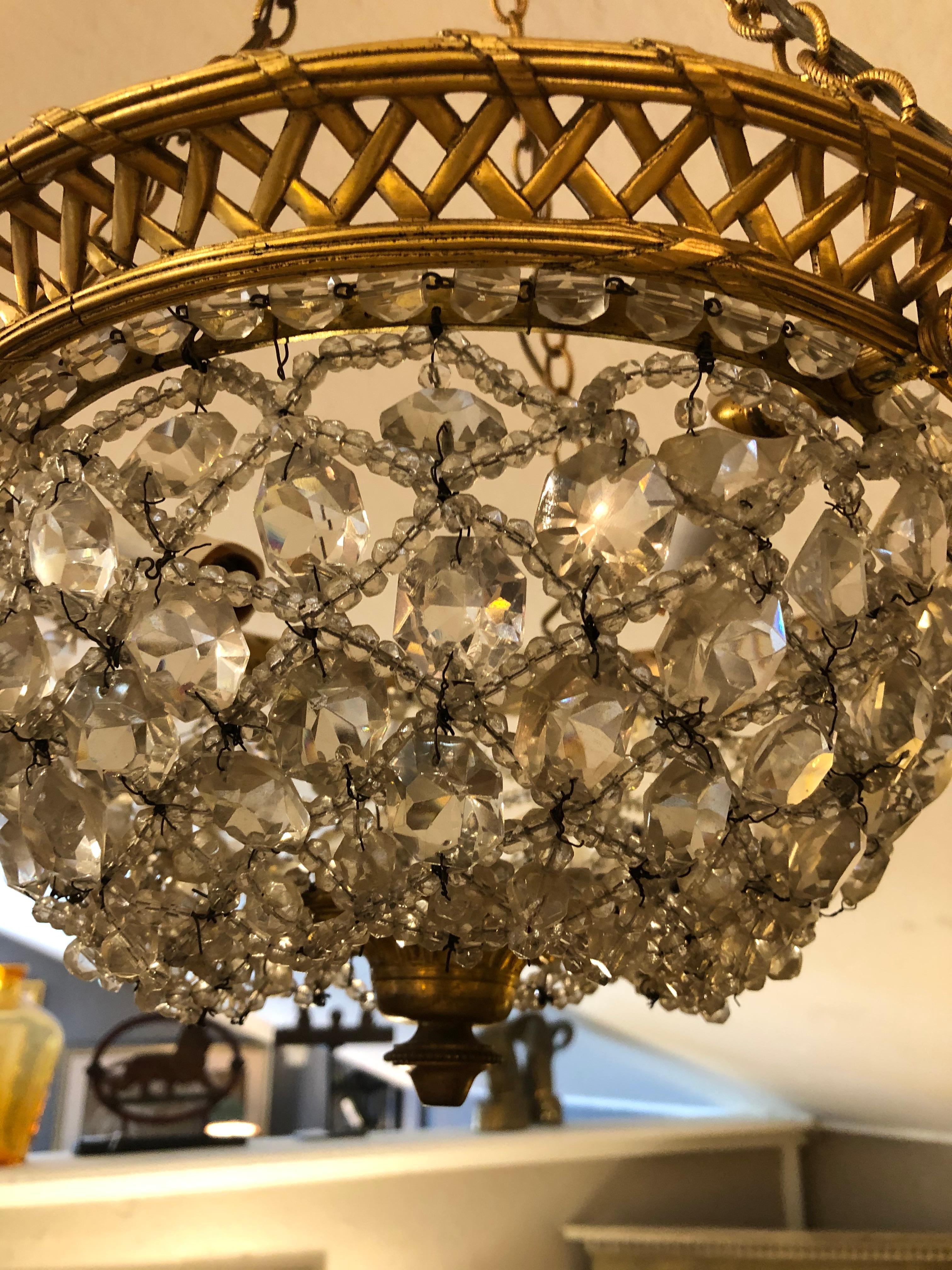 A lovely dome-shaped or basket style vintage fixture having ornate brass structure, chain and original ceiling CAP with rich crystal encrusted drop dome. 3 interior sockets for 40 watt bulbs.
Measures: Basket itself is 8