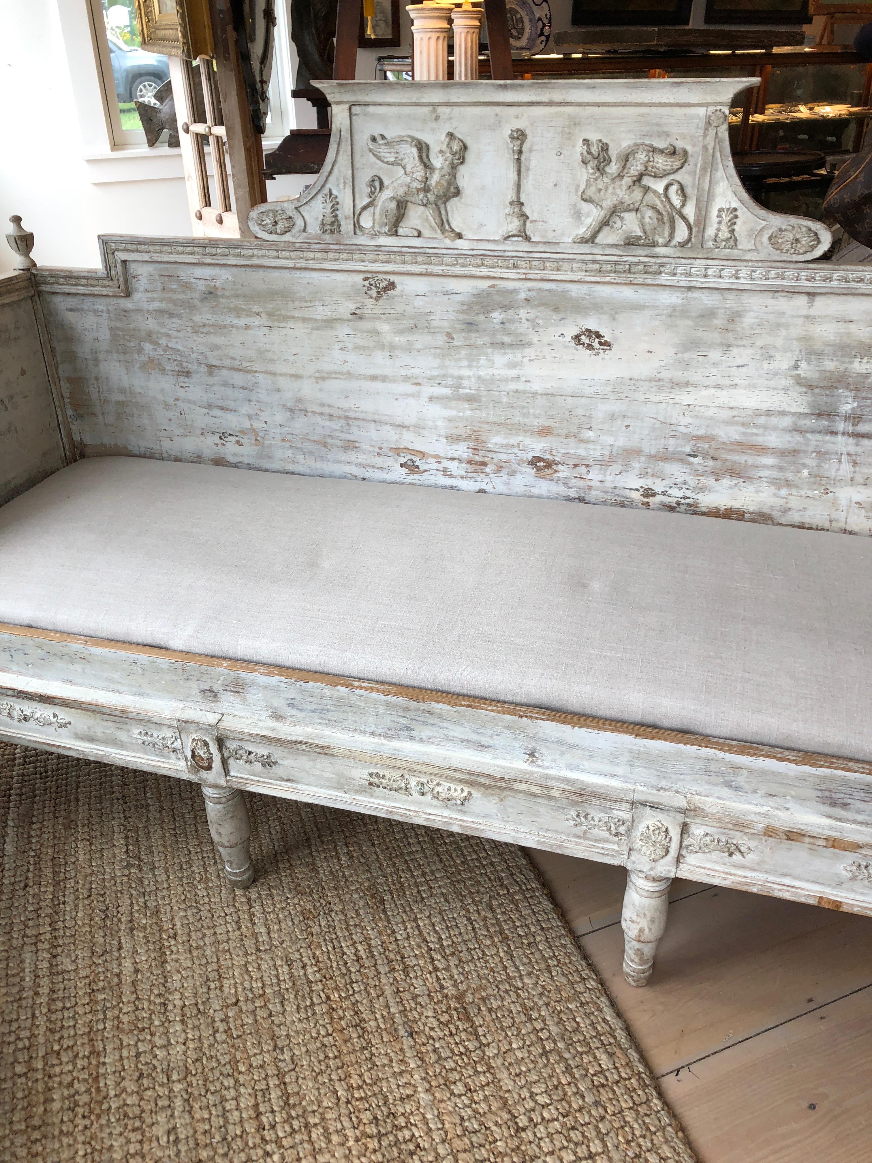 A Swedish Gustavian painted settee or sofa in a gorgeous antiqued grayish white, with beautifully carved figures and original detail. Upholstered cushion seat.
Measures: seat depth 23.