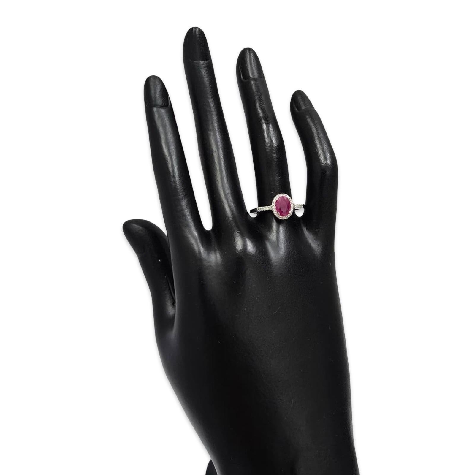 Un pezzo raffinato e femminile con un vivido rubino ovale di 0,28 carati incorniciato da una scintillante aureola di diamanti naturali. Realizzato in oro bianco massiccio 14 carati, questo anello offre un romanticismo classico con un'eleganza