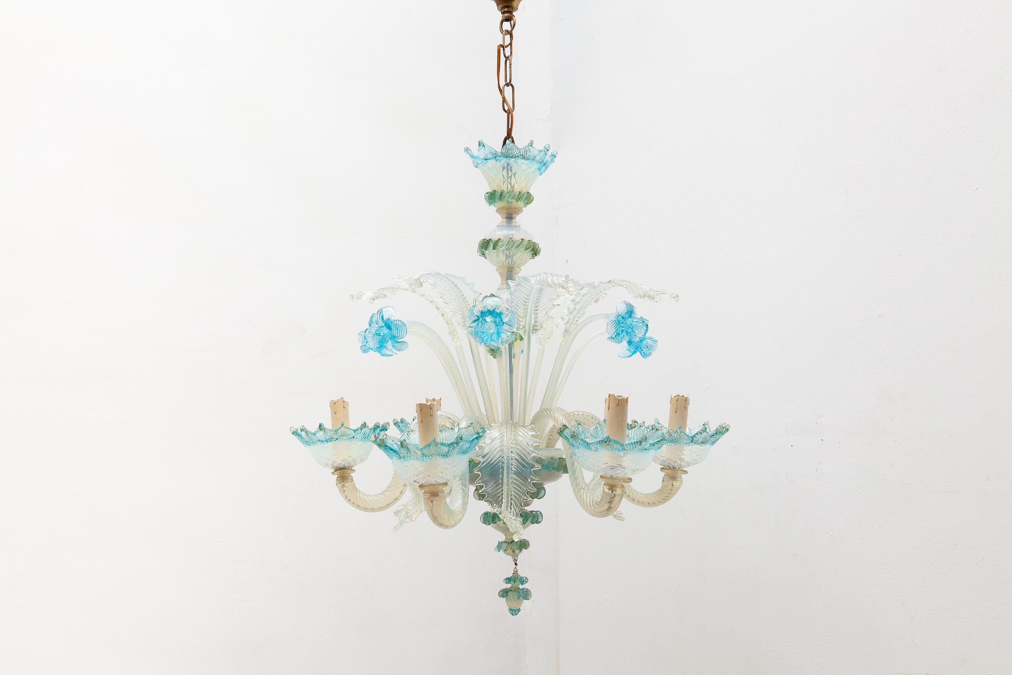 Venetian Murano glass chandelier featuring a design of intricate blue glass flowers and milk glass leaves. Lit by 6 bulbs.

Dimensions: W.55 diameter x 60 H cm :Chain length: 35 H cm.
