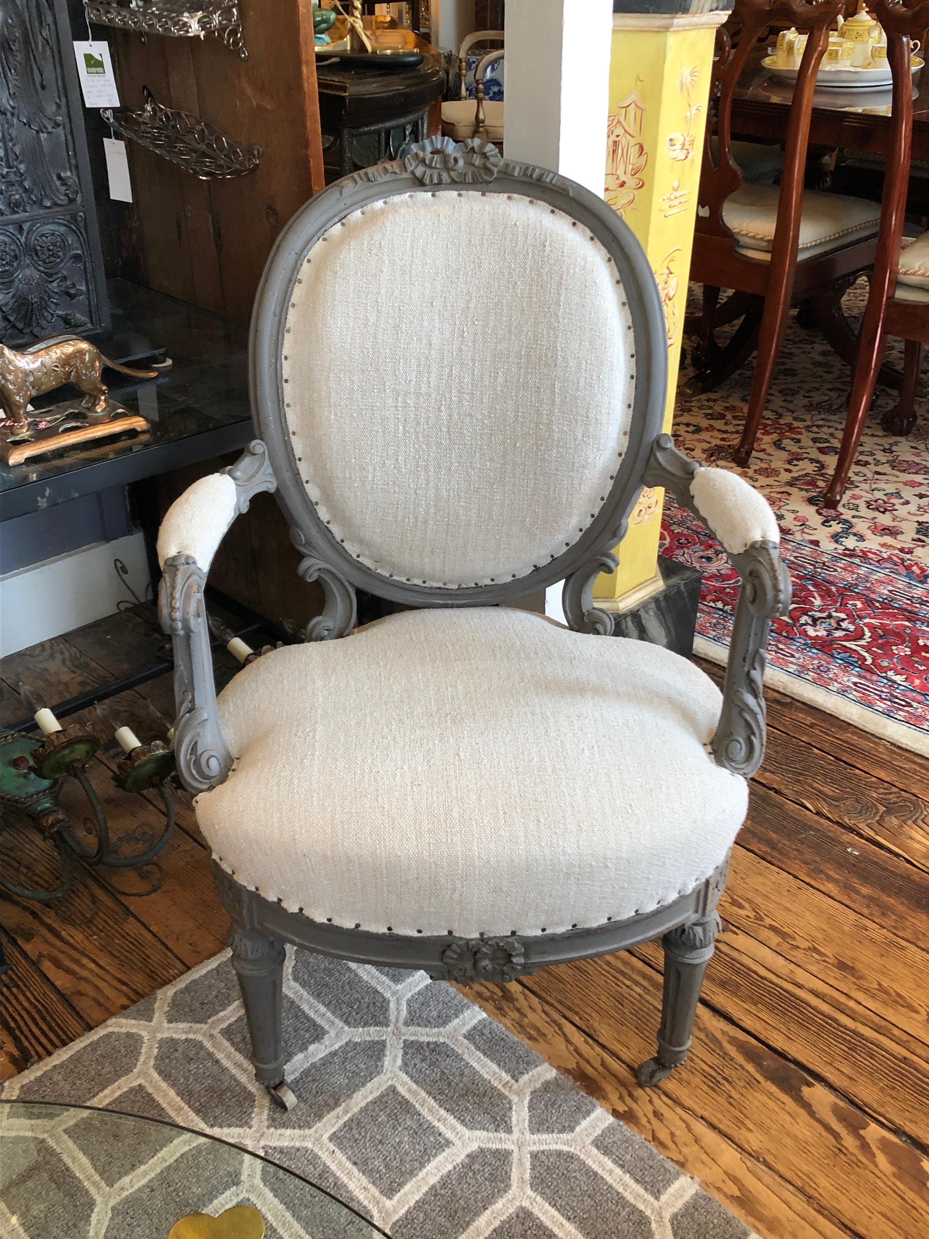 Lovely pair of French style fauteuils having carved wood frames painted a soft grey and upholstered in neutral oatmeal nubby fabric with nailhead detailing.
Measures: Arm height 24.5.