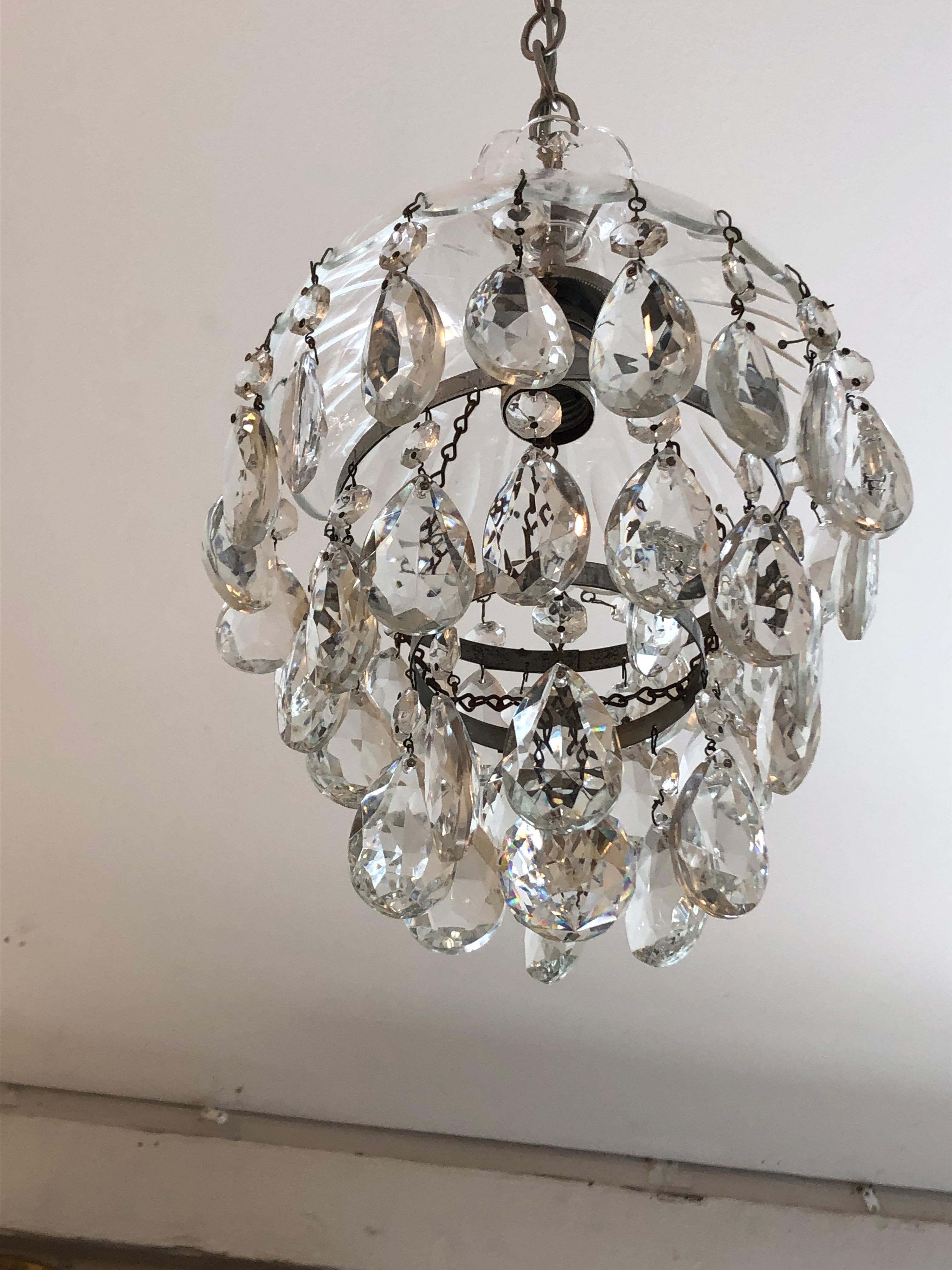 A very pretty small sized pair of glamorous pendant chandeliers having cut glass dome shaped tops and 3 levels of dripping tear drop crystals and a round crystal ball at the bottom.