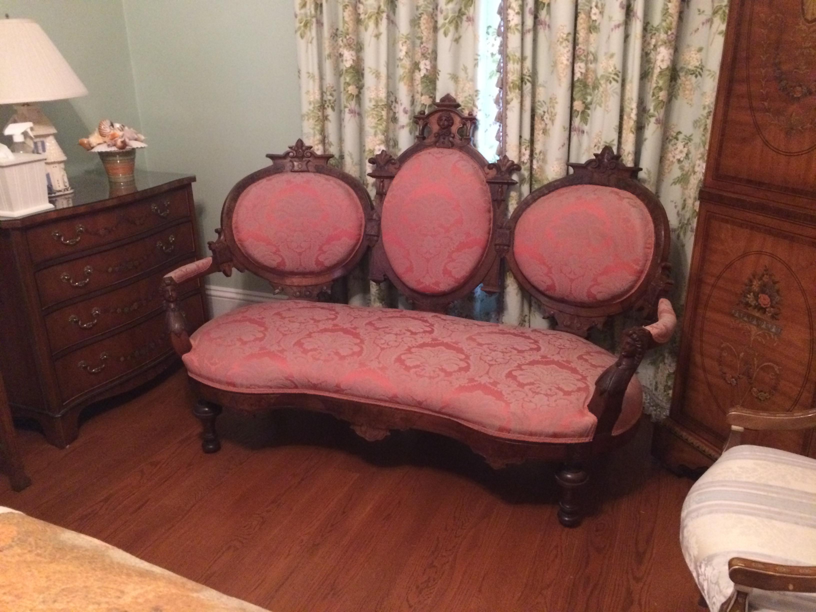 Magnificent Victorian carved walnut loveseat having ornate figural carvings of women on the arms, three oval back rests and a sexy kidney shaped seat. Upholstered in a silk jacard in a pretty shade of rasberry. Belongs in a Victoria's Secret