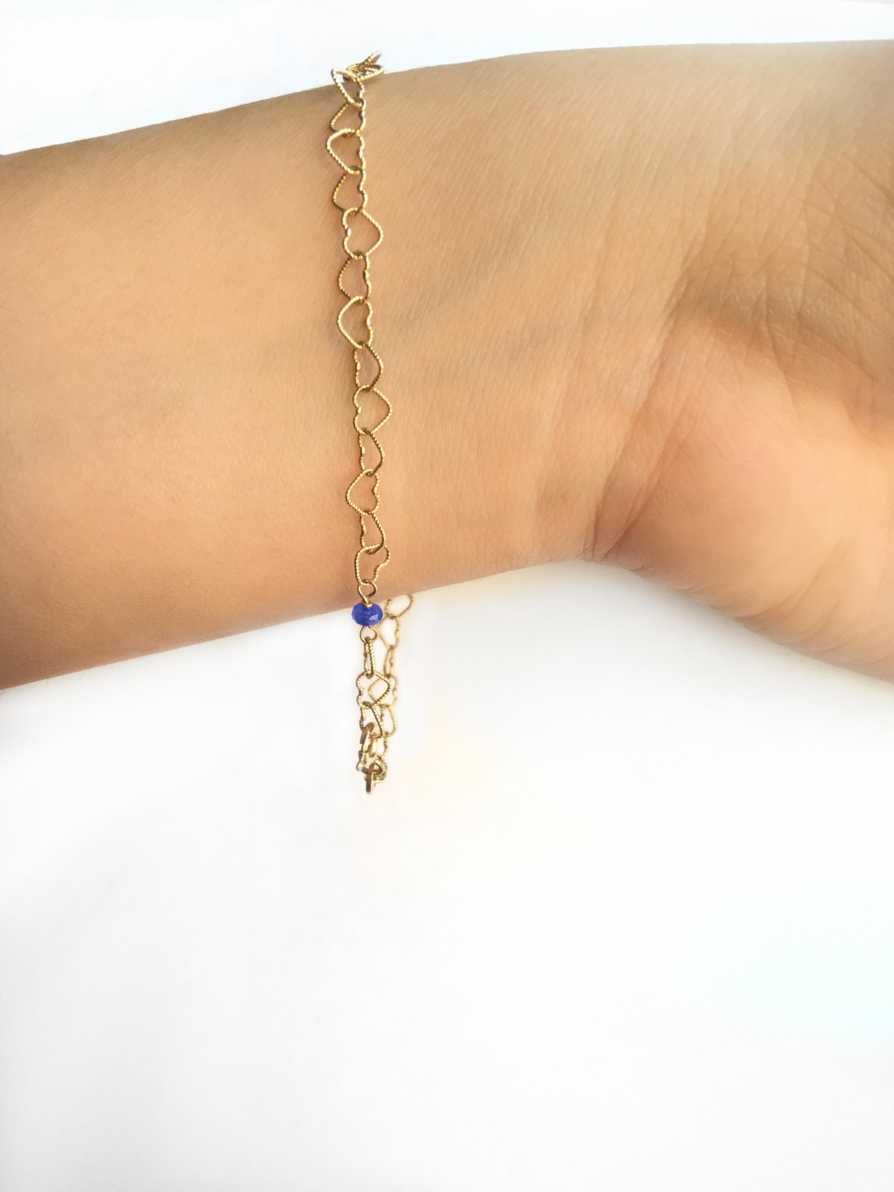 Bracelet de style romantique en or jaune 18 carats avec perles en saphir de 0,30 carat et petits cœurs.
La chaîne est reliée à la main et légèrement martelée pour épouser la forme parfaite du bracelet. Un bracelet de style romantique avec une perle