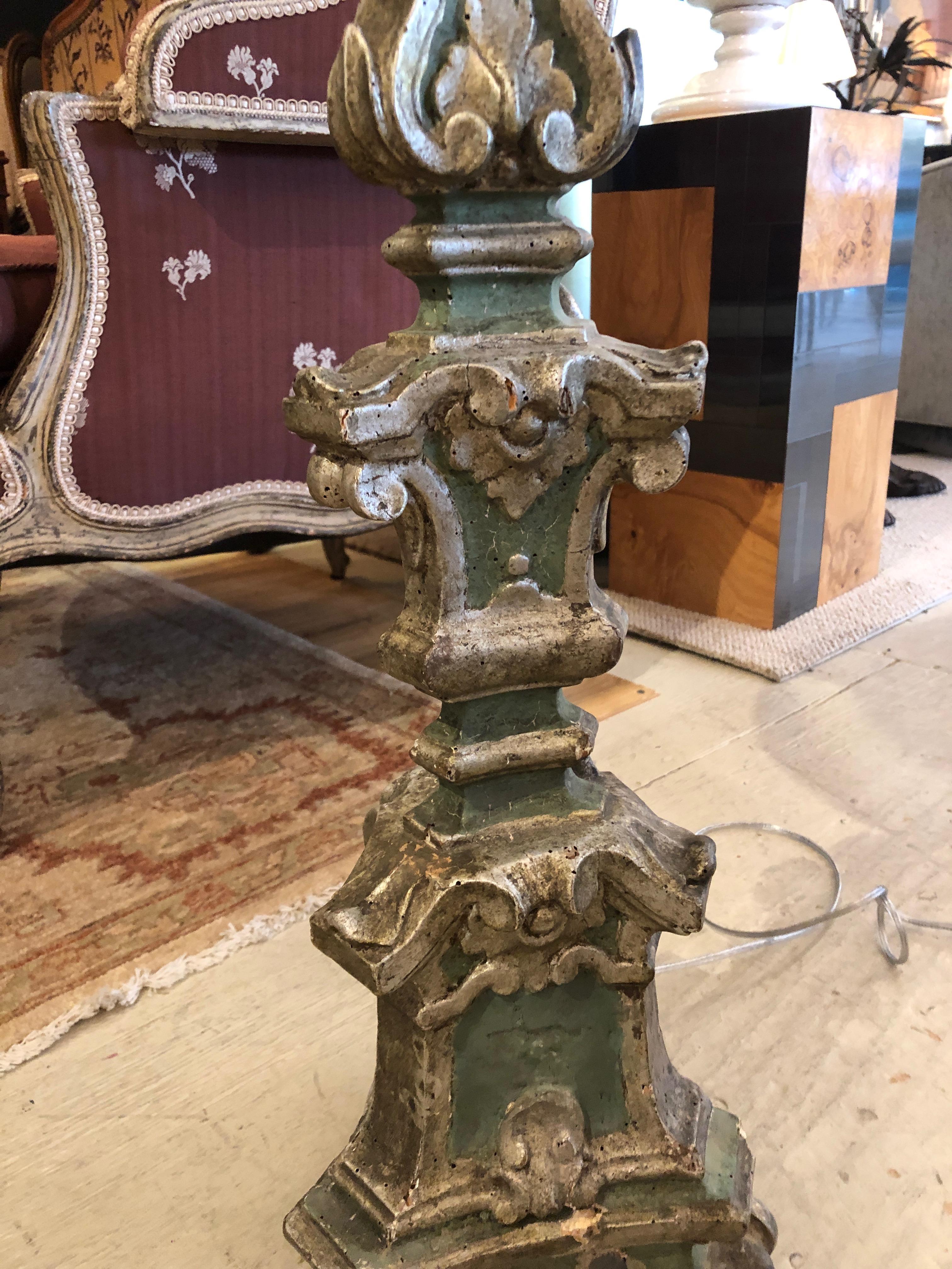 Impressively tall and romantically distressed antique pair of ornately carved wooden pricket lamps having a gorgeous celadon green painted background with silver gilded decoration. The shades are custom silk.