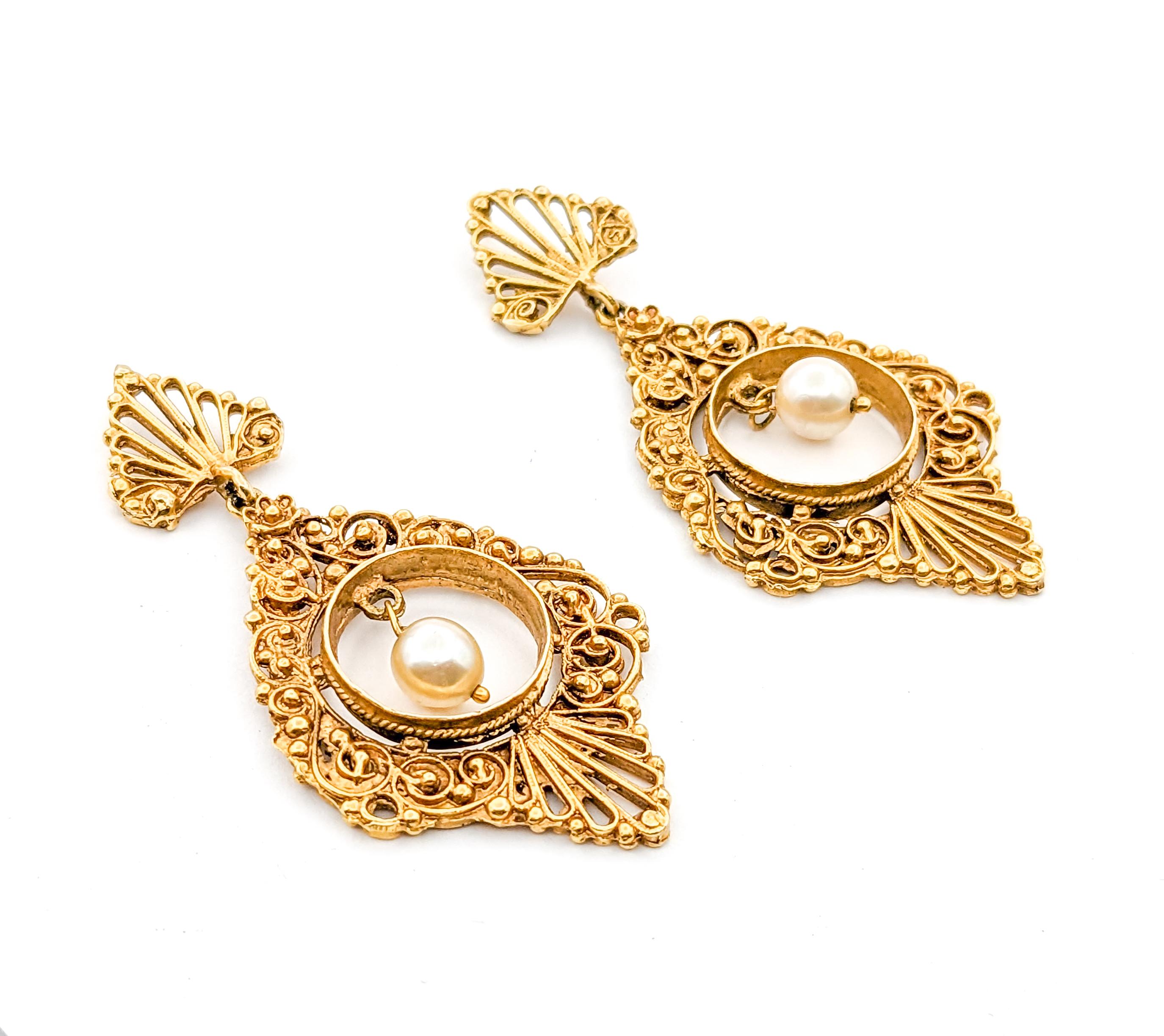 Romantic Vintage Filigree Pearl Drop Earrings in Yellow Gold

Introducing our exquisite vintage earrings, meticulously handcrafted from the finest 14k yellow gold, a testament to timeless elegance and superior craftsmanship. At the heart of each