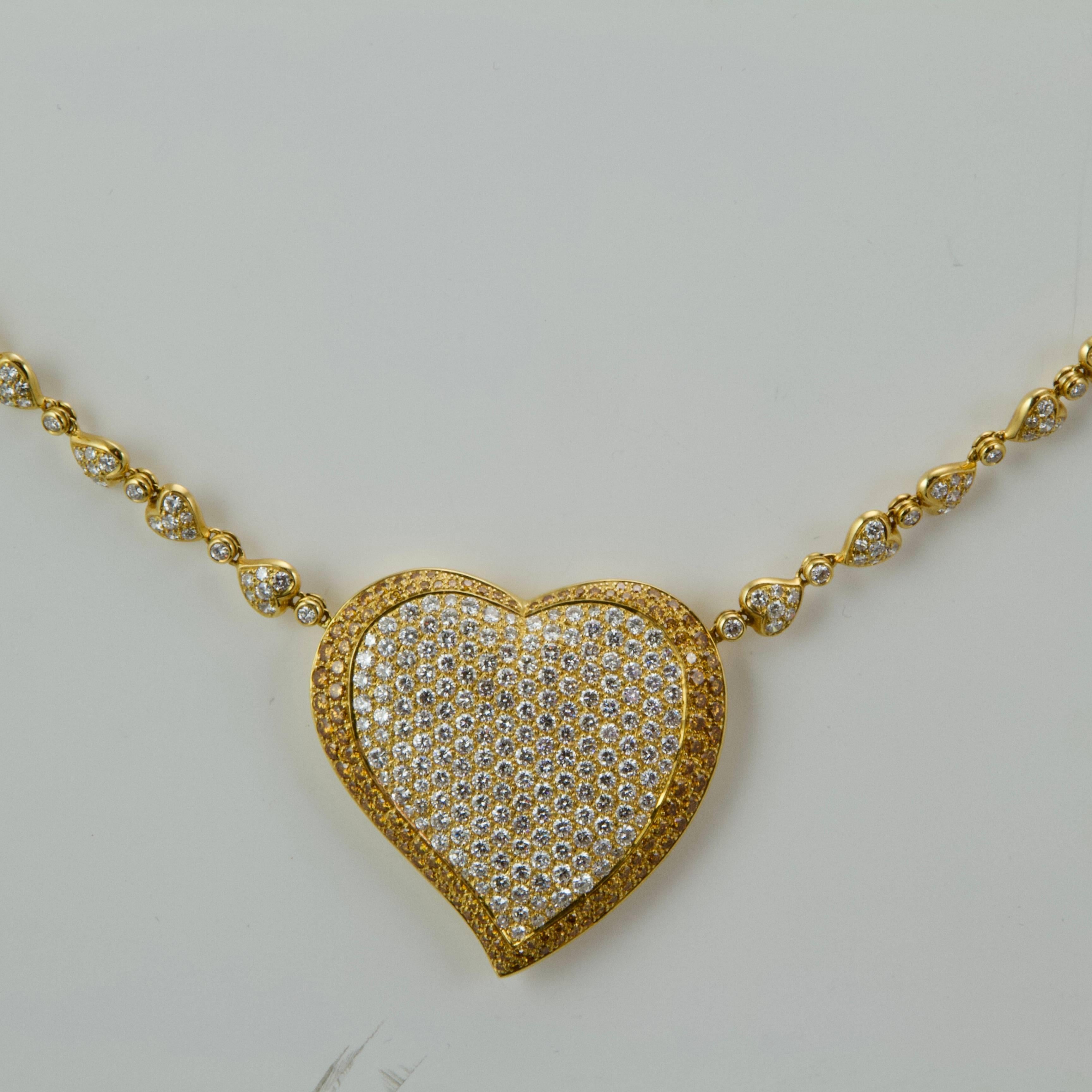 18kt yellow gold diamonds heart-shaped set comprising a necklace, a bangle, a ring and earrings clips. 
Necklace present a large heart (5 x 5 cm) set with white round cut diamonds bordered with two lines of brownish yellow round cut diamond for a