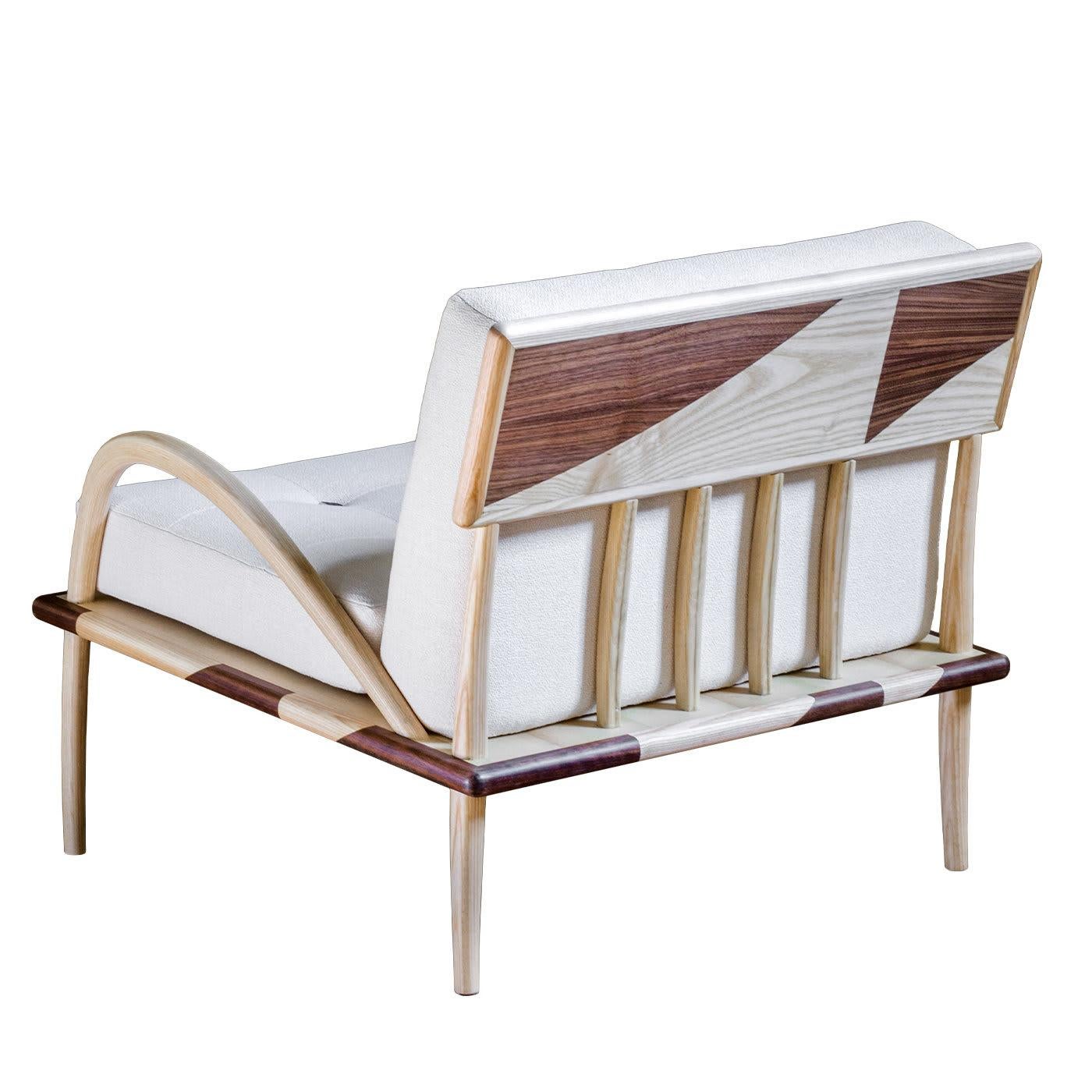 Ce fauteuil exquis est une vitrine de la maîtrise de la menuiserie, avec sa silhouette intrigante obtenue en mélangeant le frêne naturel et le noyer Canaletto. Équipé d'un coussin d'assise et de dossier en peluche recouvert d'un tissu blanc