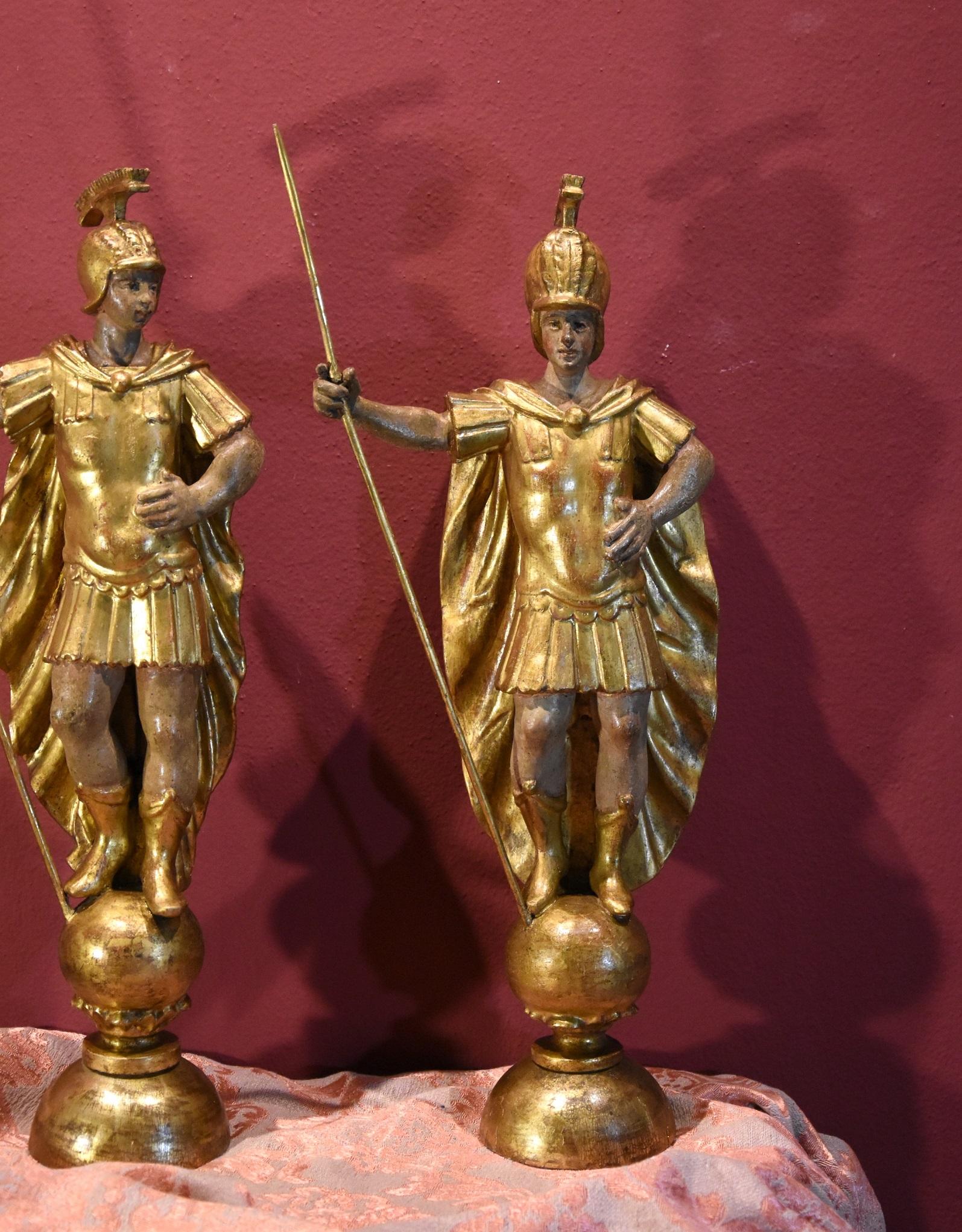 Wooden sculptures depicting a pair of full-length Roman soldiers
Rome, 18th century
Carved and gilded wood (walnut?)

Dimensions: Maximum height (at lance) 62 cm./ Maximum width: 28 cm.

Pair of wooden sculptures depicting two Roman centurions,