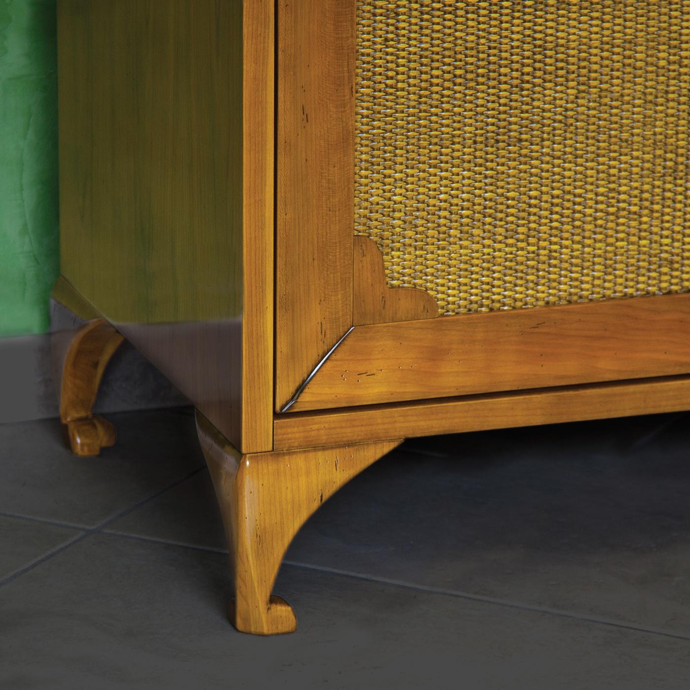 Splendide pièce de sophistication classique à assortir avec le buffet Romeo, ce meuble est fabriqué en bois de cerisier massif et comporte deux portes recouvertes d'un tissu piqué canette jaune pâle avec des poignées à tirette en laiton finition