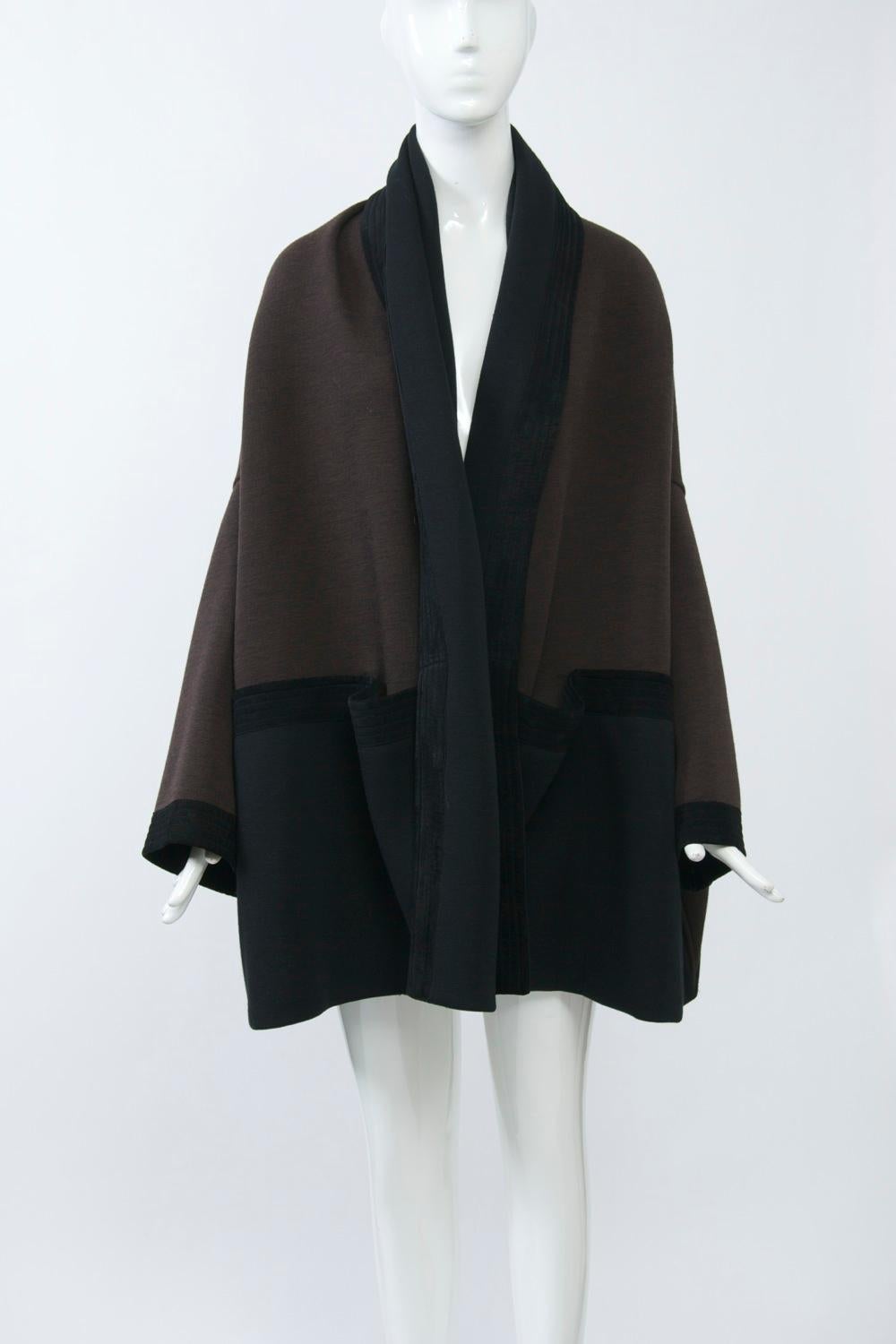 Romeo Gigli designs are highly sought after. This jacket, composed of black and brown wool knit trimmed in black suede, has an oversized kimono silhouette. The black suede borders are channel-stitched and, where they horizontally separate the brown