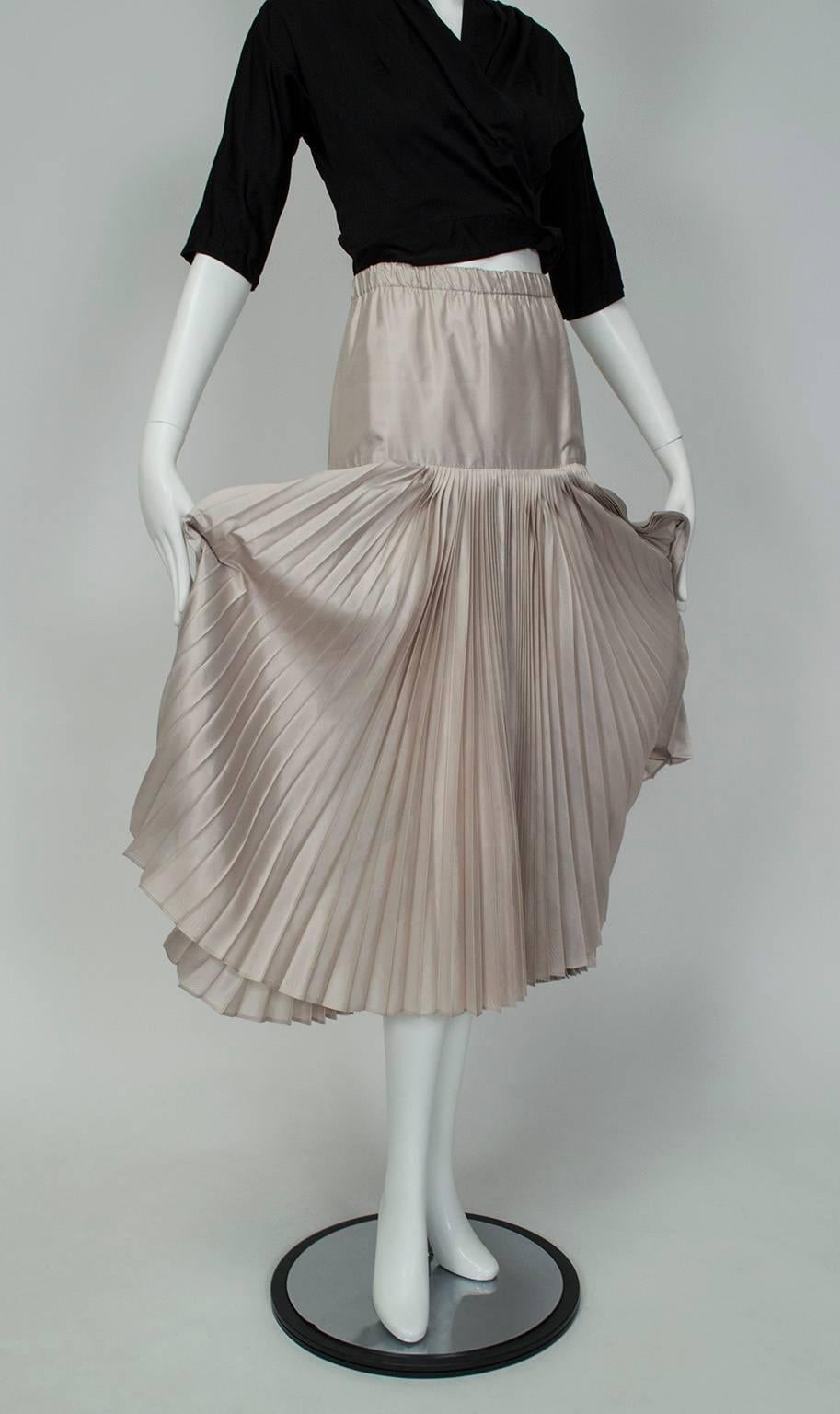 With thirteen yards of ultra-luxe accordion pleated silk, this skirt has enough fabric to make a full set of drapes (but the dramatic sweep, fetching rear slit and unusual changeante color wouldn't make nearly the impact on your walls as it will on