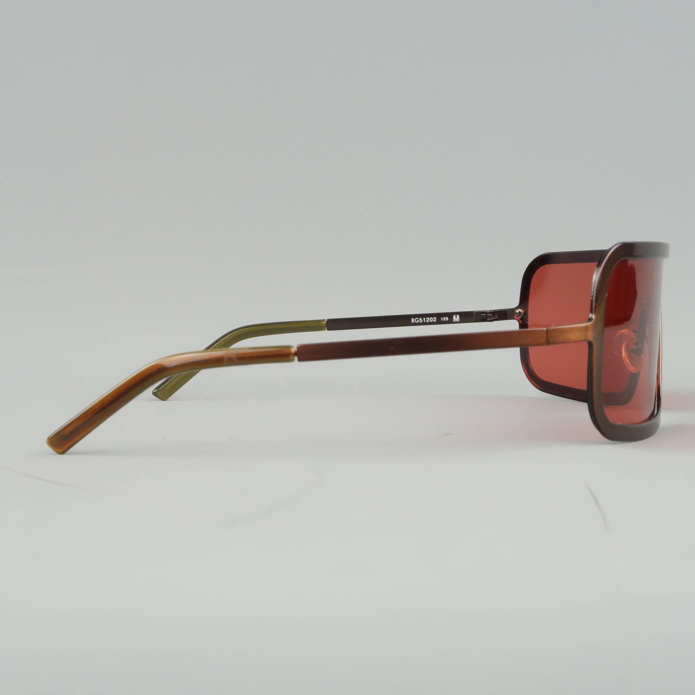 Archive ROMEO GIGLI sunglasses come in brushed copper tone metal with a red shield lens. Made in Italy.
 
Good Pre-Owned Condition.
Marked: RG51202 125
 
Measurements:
 
Length: 14.5 cm
Height: 4.75 cm.
