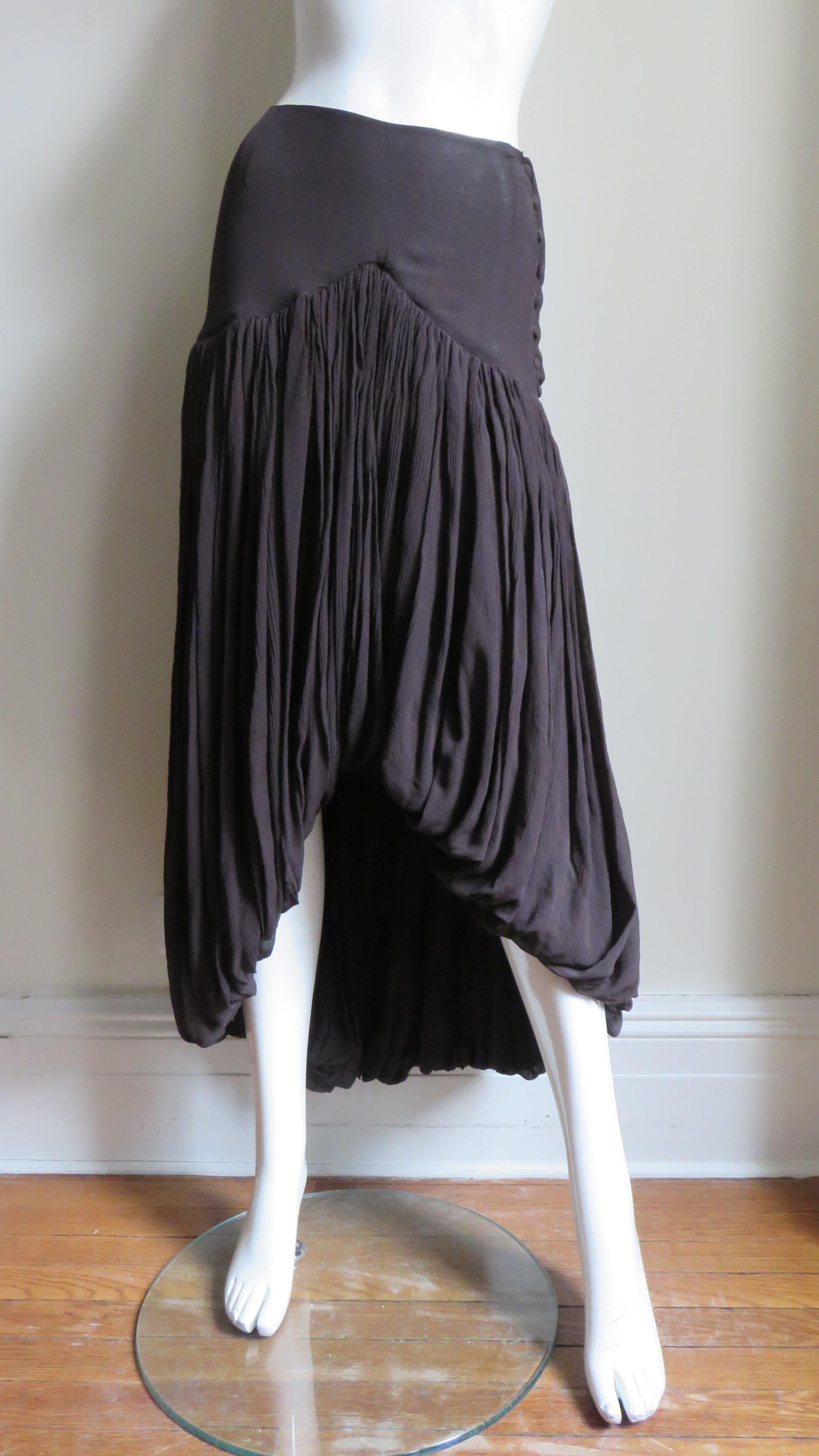 A fabulous rich brown silk skirt from Romeo Gigli.  It has an inverted V yoke in the front and a straight yoke in the back.  The skirt is gathered on to the yokes draping to the hem. The skirt is shorter in the front forming a rounded inverted V