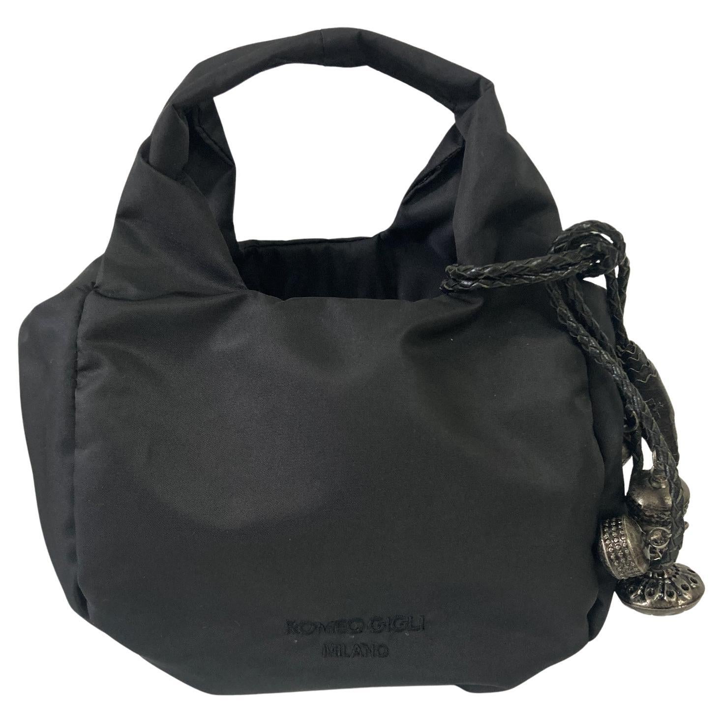 Romeo Gigli mini bag from c.a. 2000s. It is a testament to the brand's artistic sensibility. Crafted from durable black nylon, the bag's true charm lies in its intricately designed embellishments. Detailed earthy ethnic charms are attached with