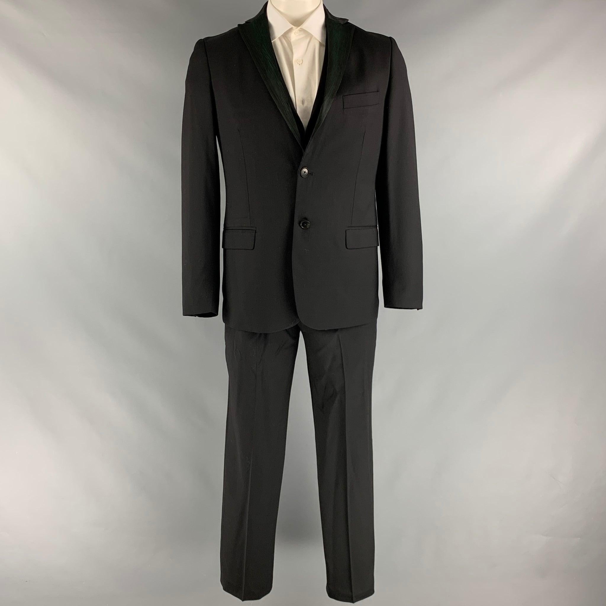 Le costume 3 pièces de Romeo GIGLI est en laine tissée noire et verte avec une doublure complète. Il comprend un manteau de sport à double boutonnage à revers échancré, un gilet assorti et un pantalon à devant plat. Fabriqué en Italie. Excellent