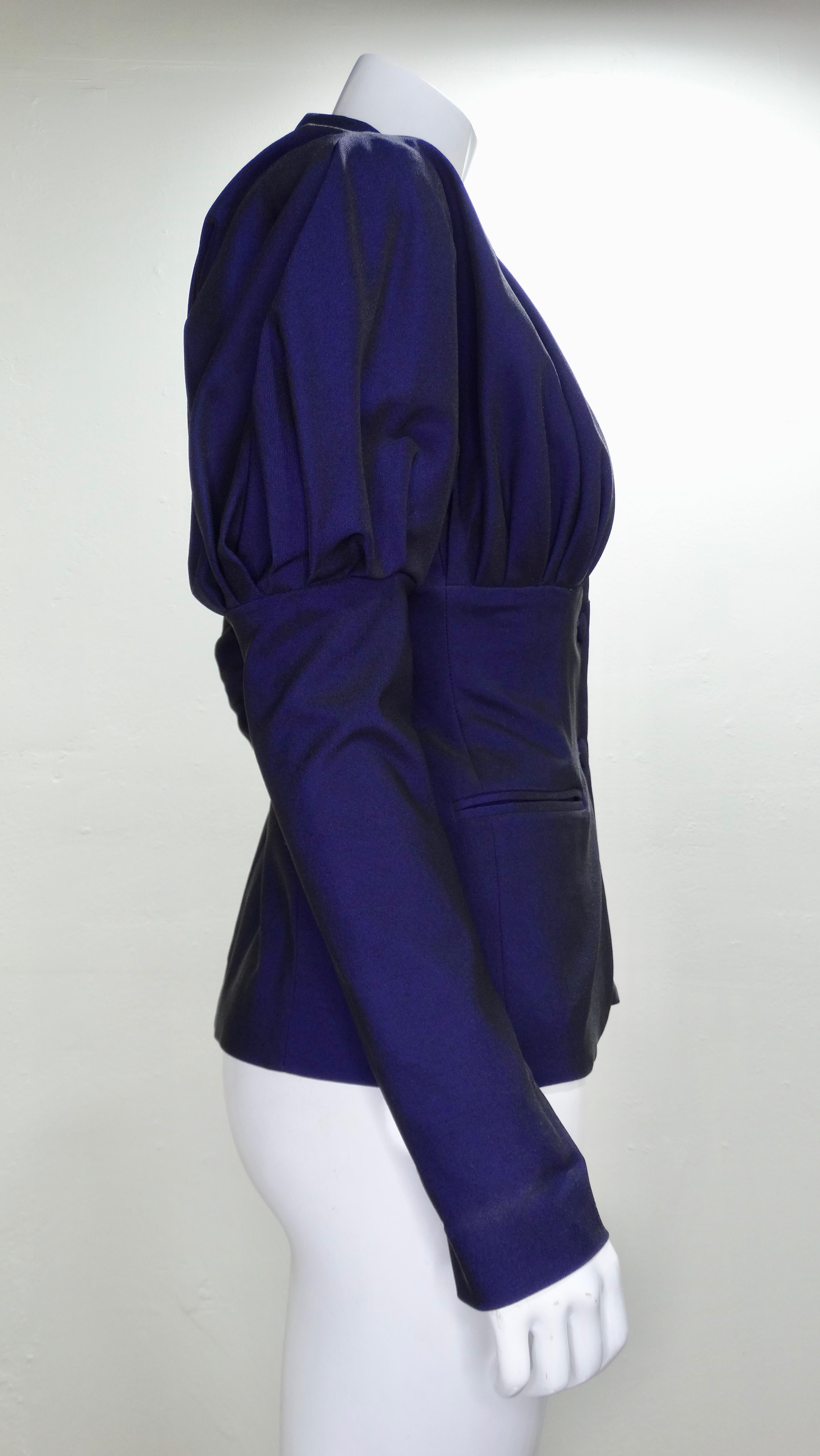 Circa late 1980s, this stunning Romeo Gigli Victorian style blazer features a beautiful deep iridescent purple color and large leg-o-mutton sleeves. Pleating on the Yoke back and the bust create a gorgeous structured silhouette. Matching coated