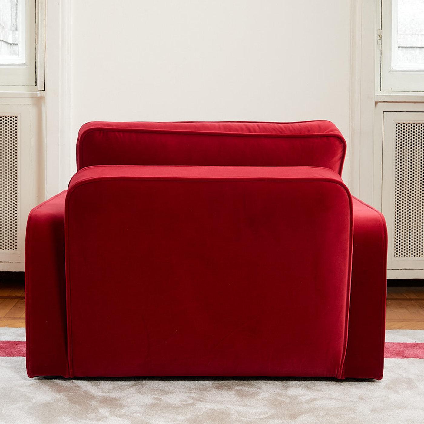 Elegant in its lines and proportions, this sumptuous armchair stands out for its bright red fabric upholstery guaranteeing softness and extra comfort to the whole. The impeccable proportions defining the richly padded wooden frame guarantee