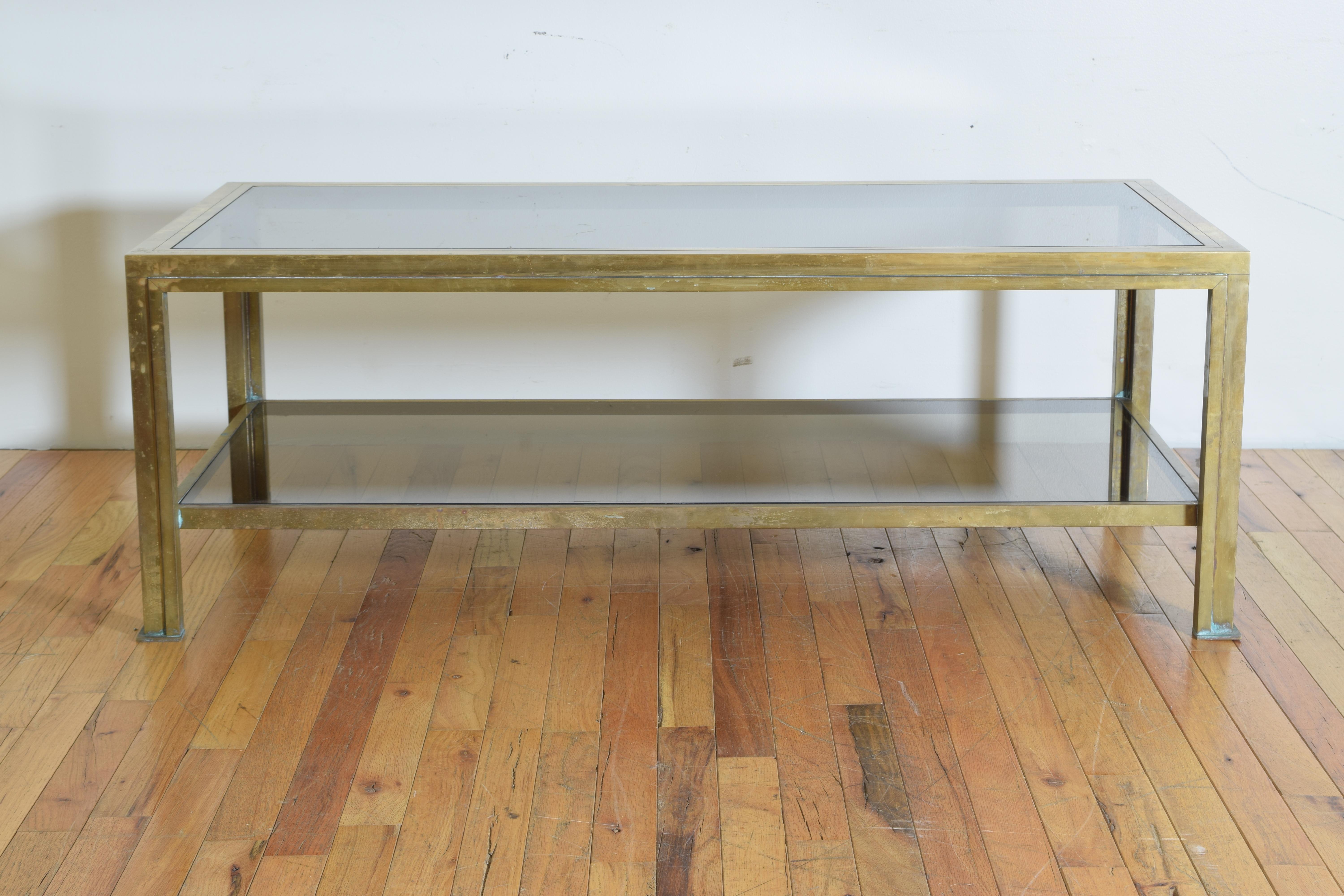 Rare and fantastic solid brass and two-tiered coffee table with the original smoked glass.