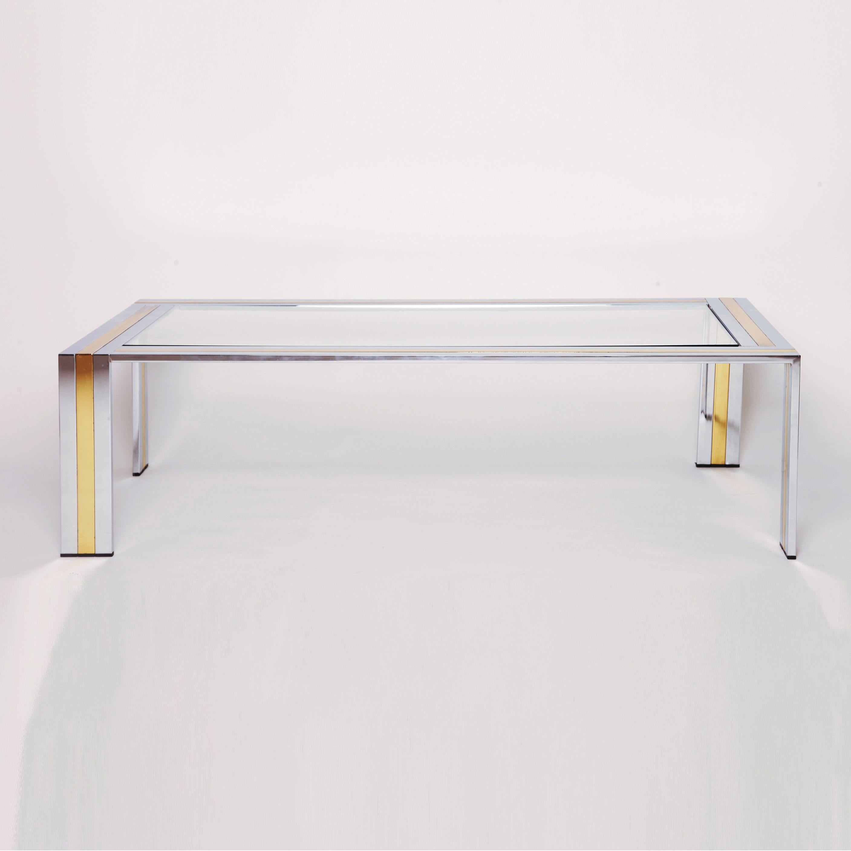 Chrome and brass rectangular coffee table attributed to Romeo Rega. Chrome stripped with a middle brass plated stripe. Clear glass top.