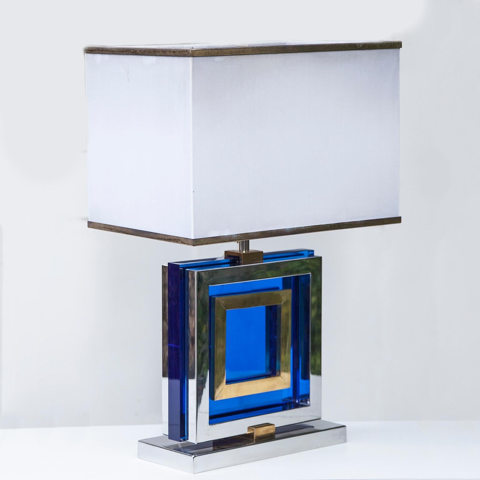 Elegant and sophisticated Hollywood style table lamp in blue Lucite and chromed brass details from Italy 1970s, signed Romeo Rega on the base. Silk shade with brass rim.