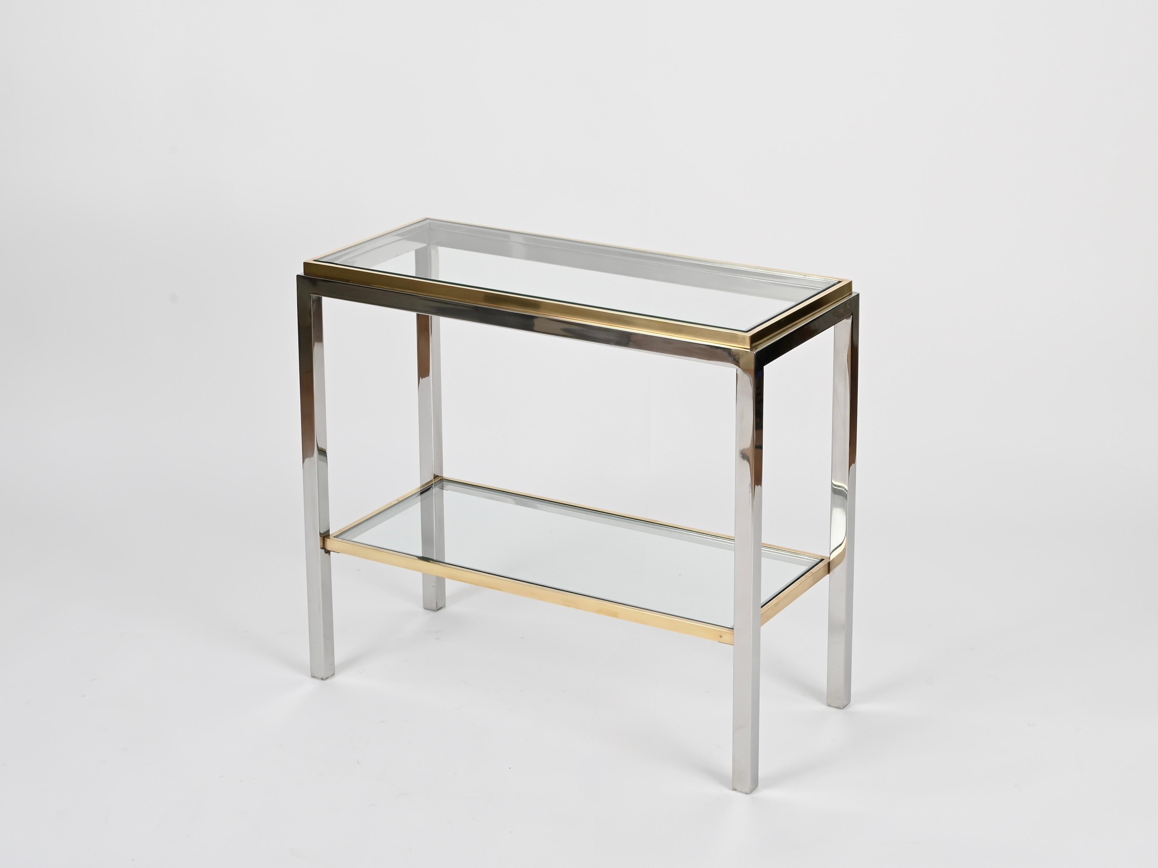 Wonderful Mid-Century side table or small console table, crafted in a charming combination of chrome and brass with two crystal glass tops. This incredibly stylish piece was designed by Romeo Rega and produced in Italy during the 1970s.

In fabulous