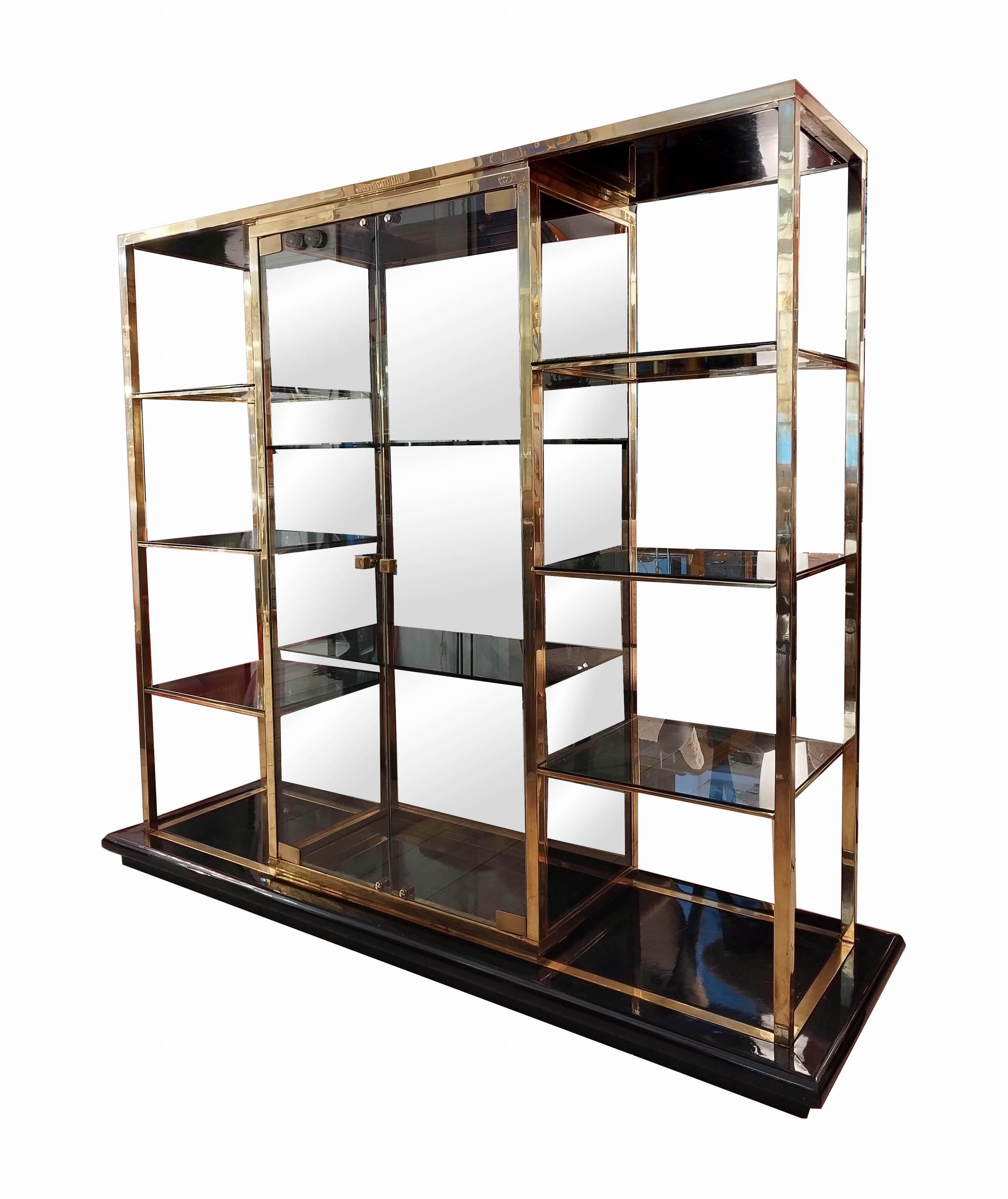 Etagere, display case, bookcase, made of brass on a black lacquered wooden base, the etagere consists of a central two-door display case with brass handles, 6 glass shelves' fume, the lower and upper bases are made of black lacquered wood This piece